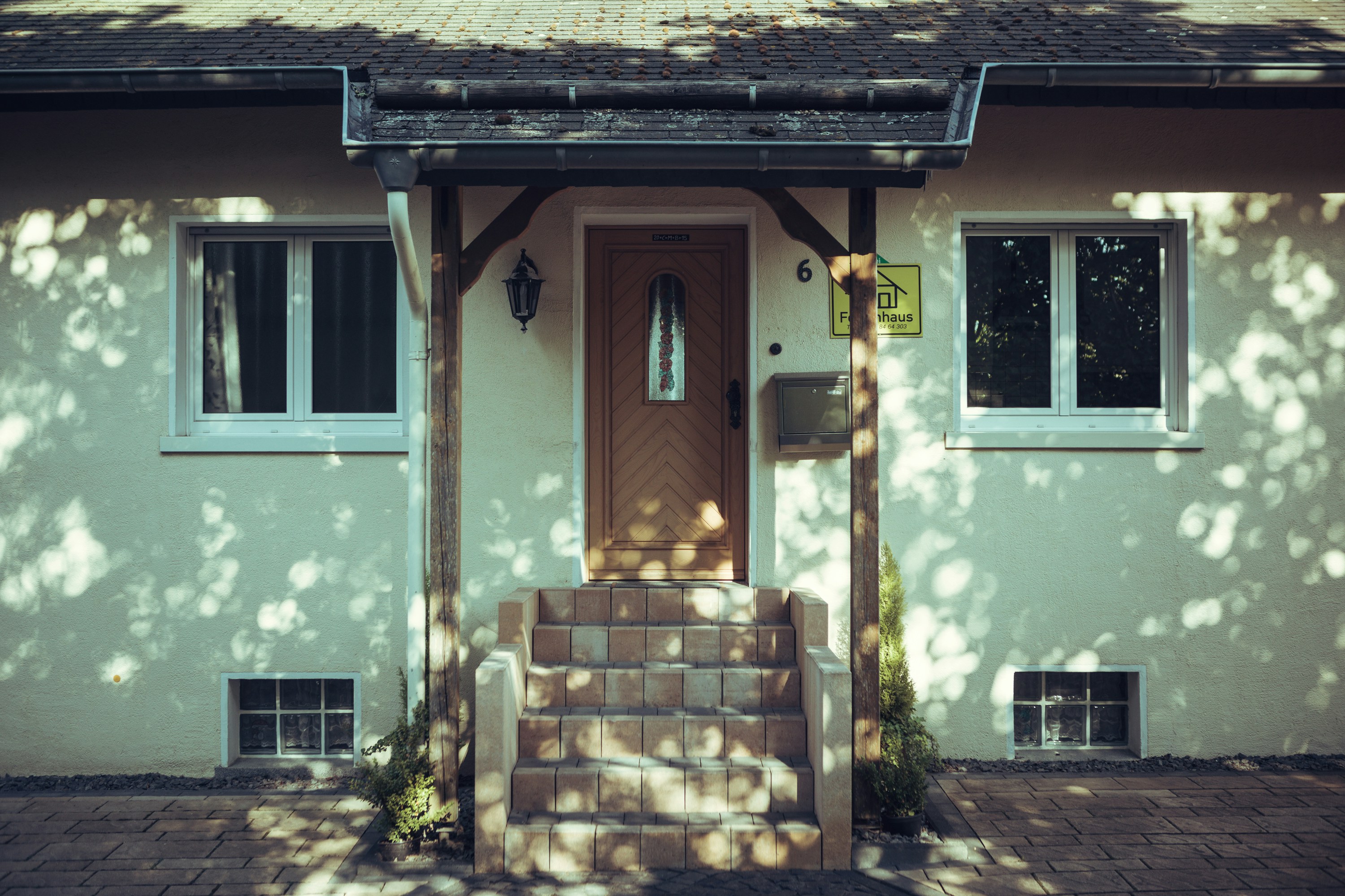 A white house with a brown door and steps