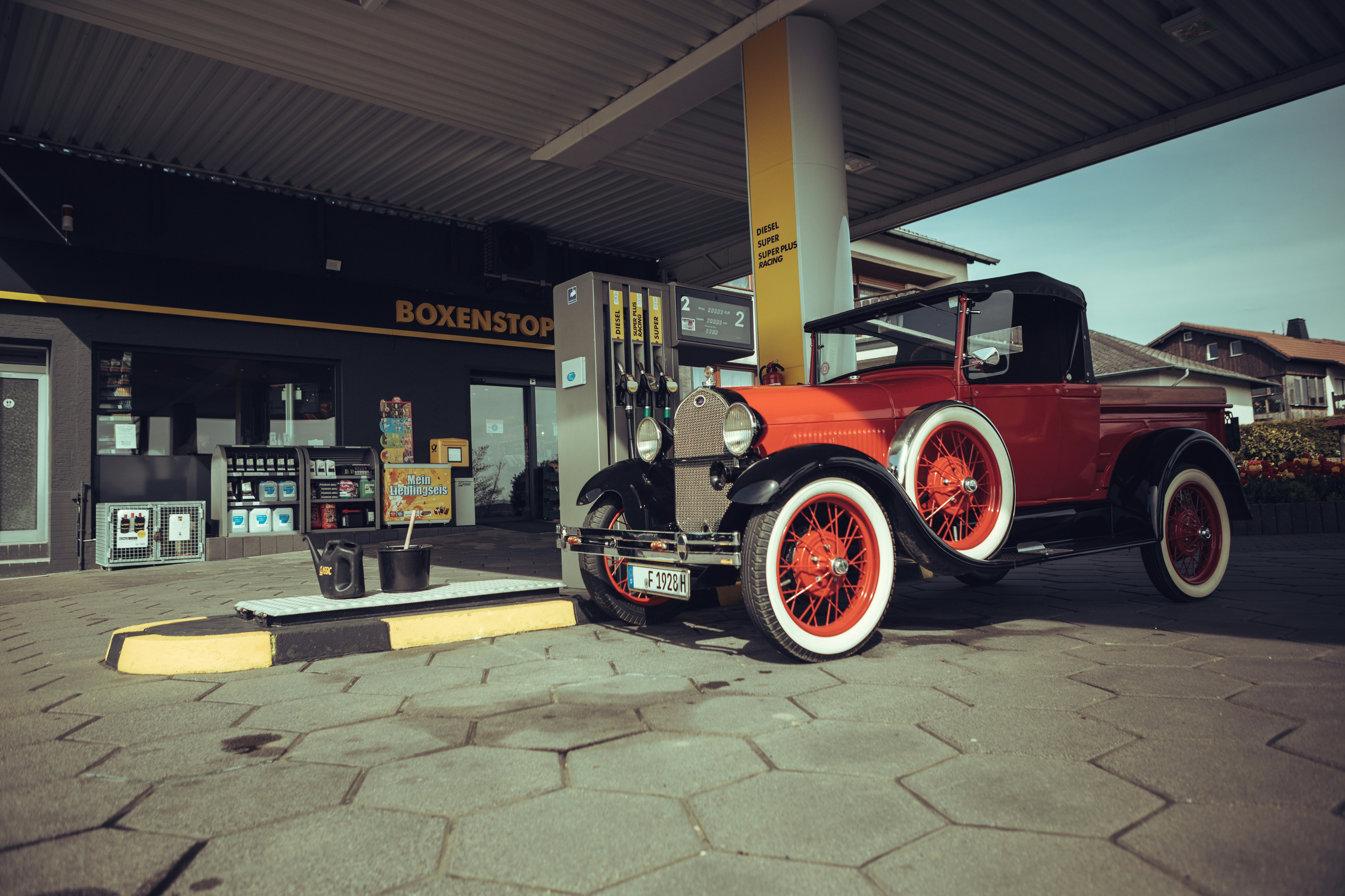 A red truck parked in front of a gas station