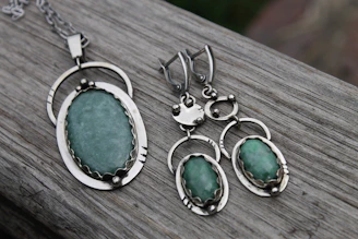 Three pieces of jewelry sitting on top of a wooden table