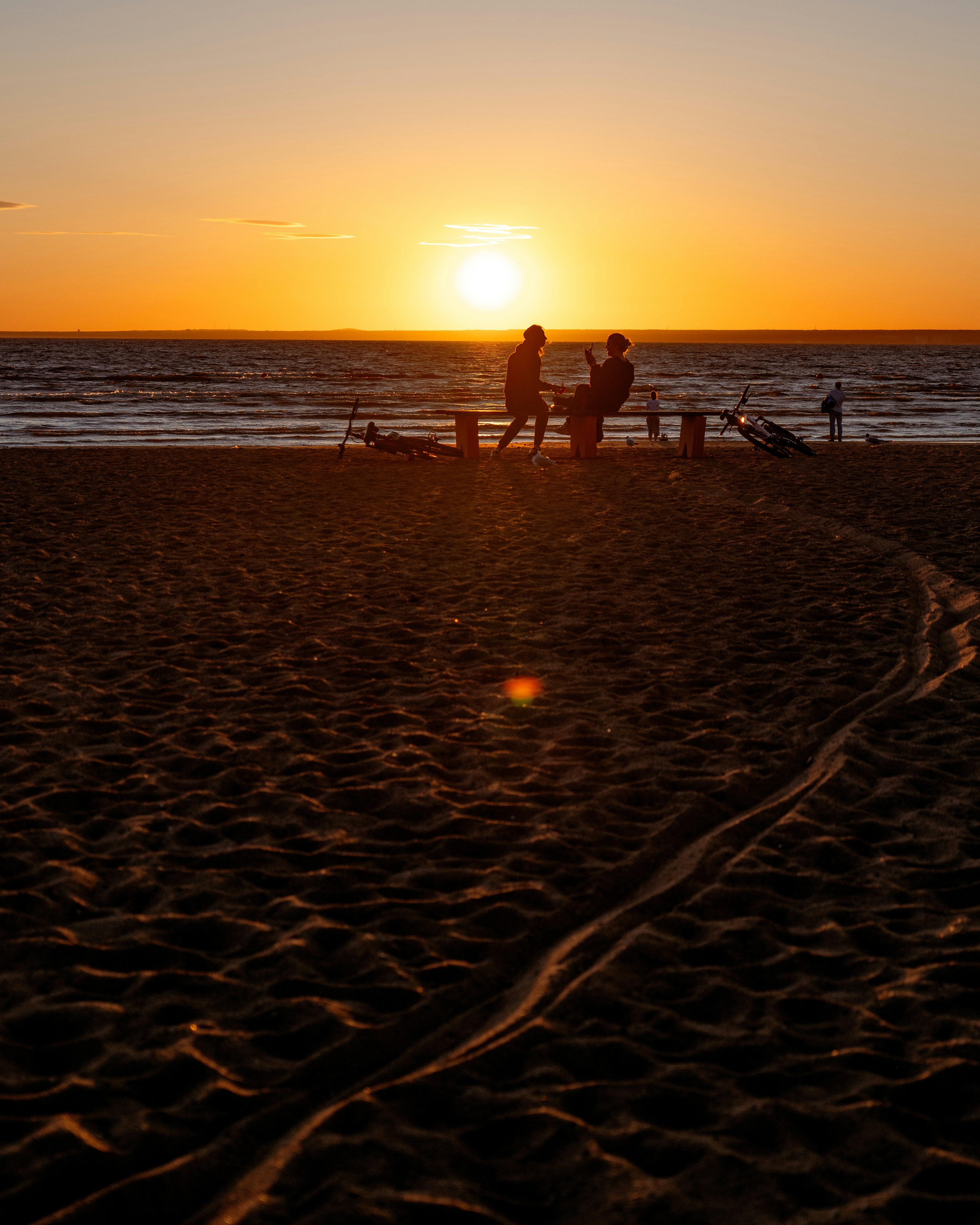 Quelques personnes debout au sommet d’une plage de sable