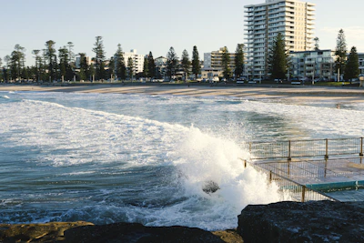 A large wave crashing into the shore of a beach