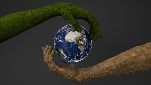 Two hands are holding a small earth globe