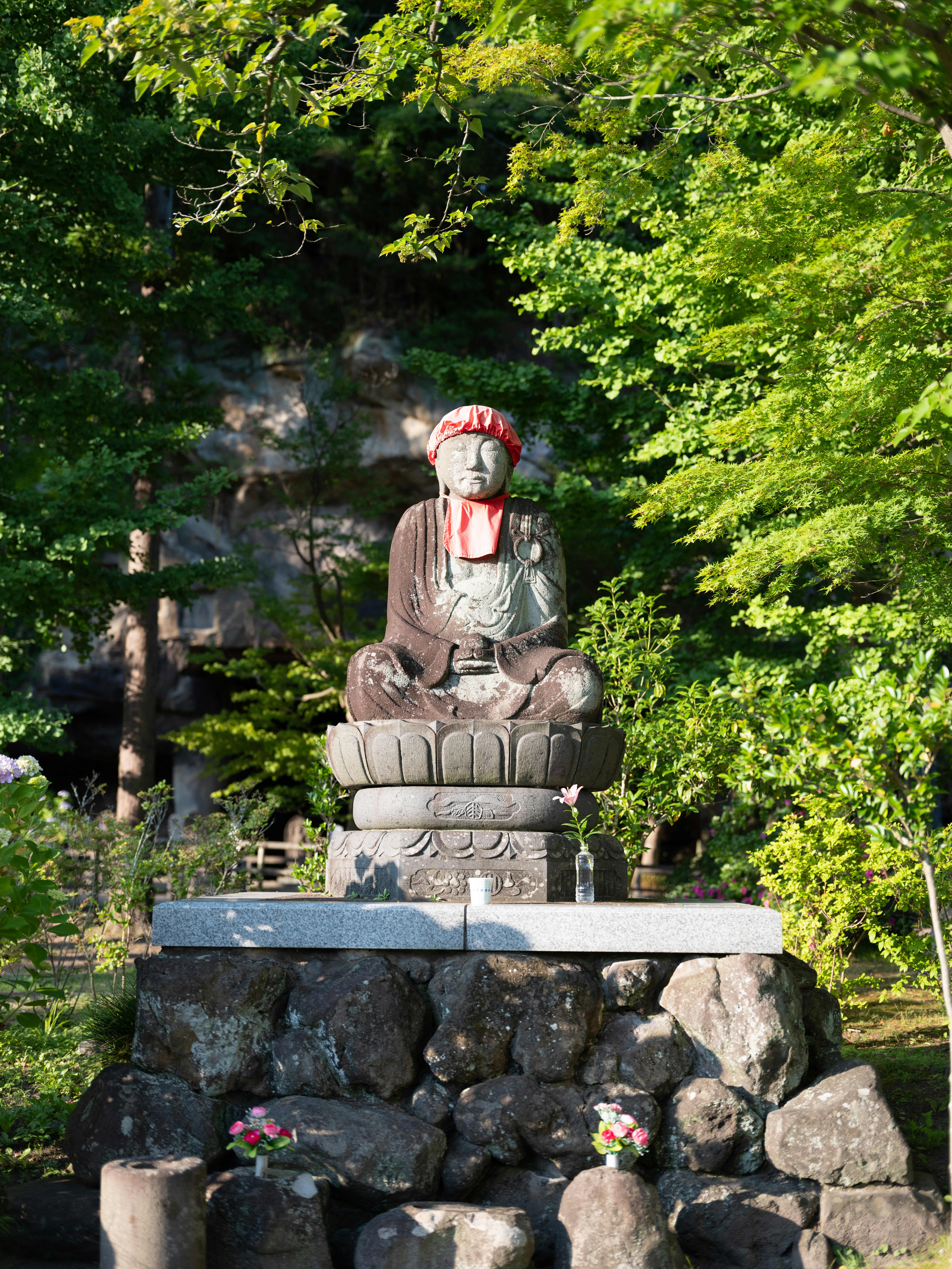 A statue of a man sitting on top of a pile of rocks