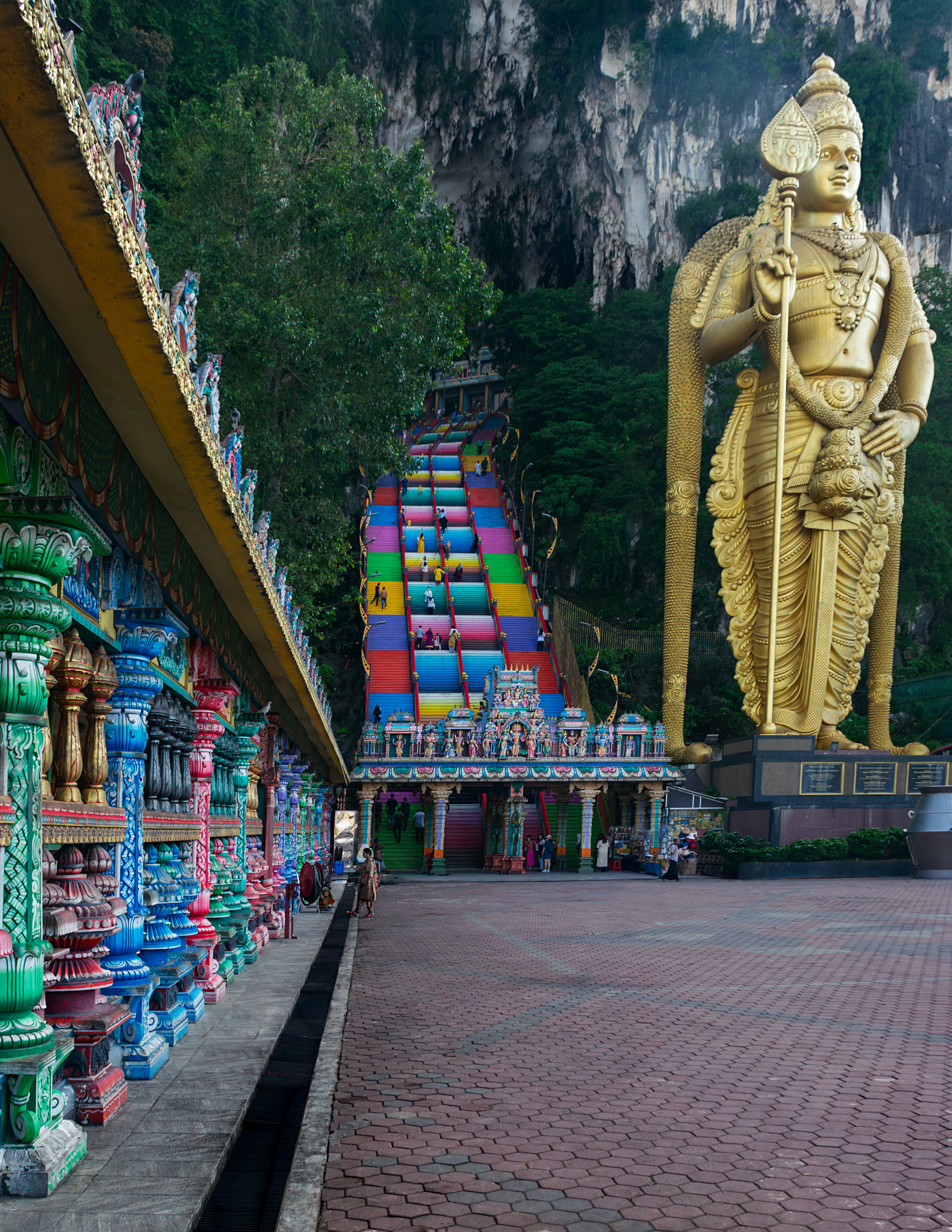 A statue of a man holding a staff in front of a mountain