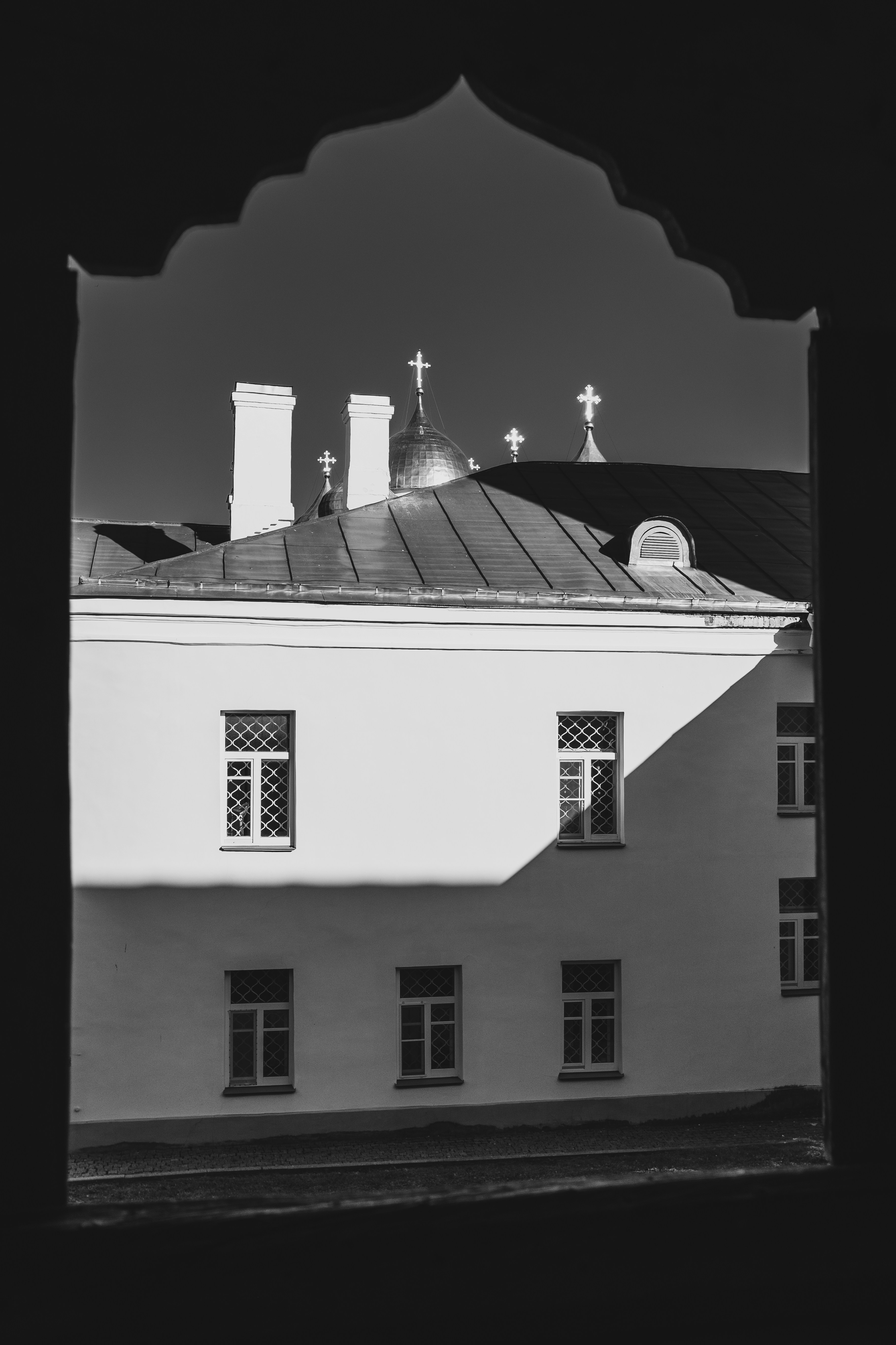 Una foto in bianco e nero di un edificio con una croce in cima