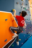 A young boy climbing on a climbing wall