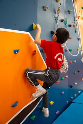A young boy climbing on a climbing wall