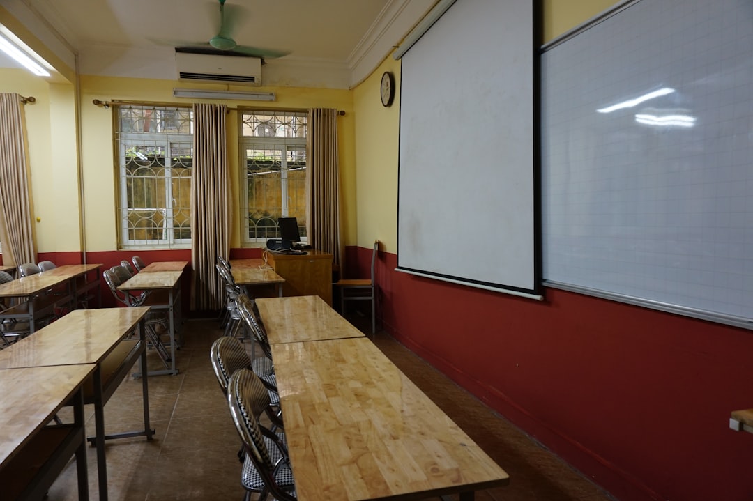 A classroom with tables and chairs and a whiteboard