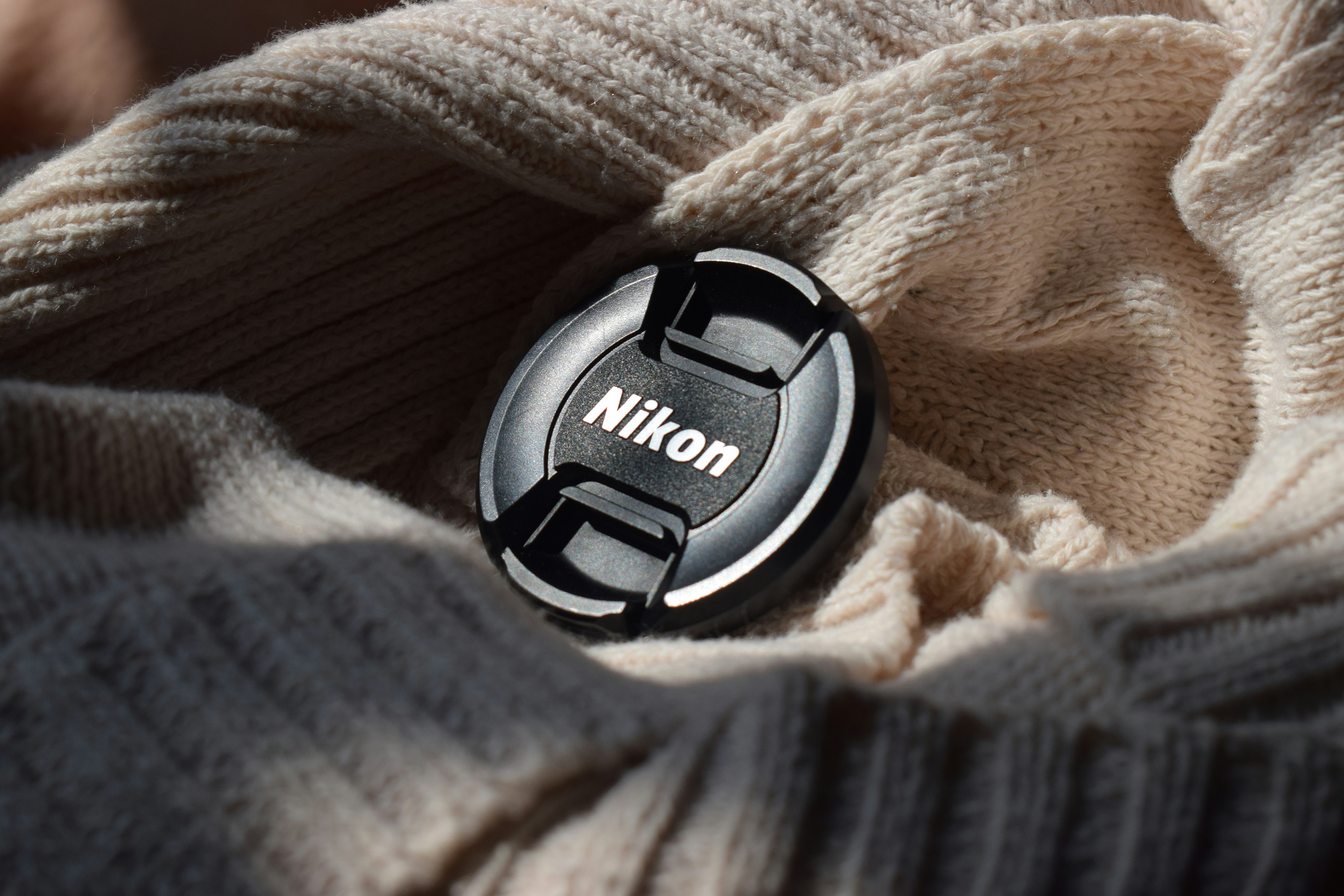 A button on a sweater that says nik on it
