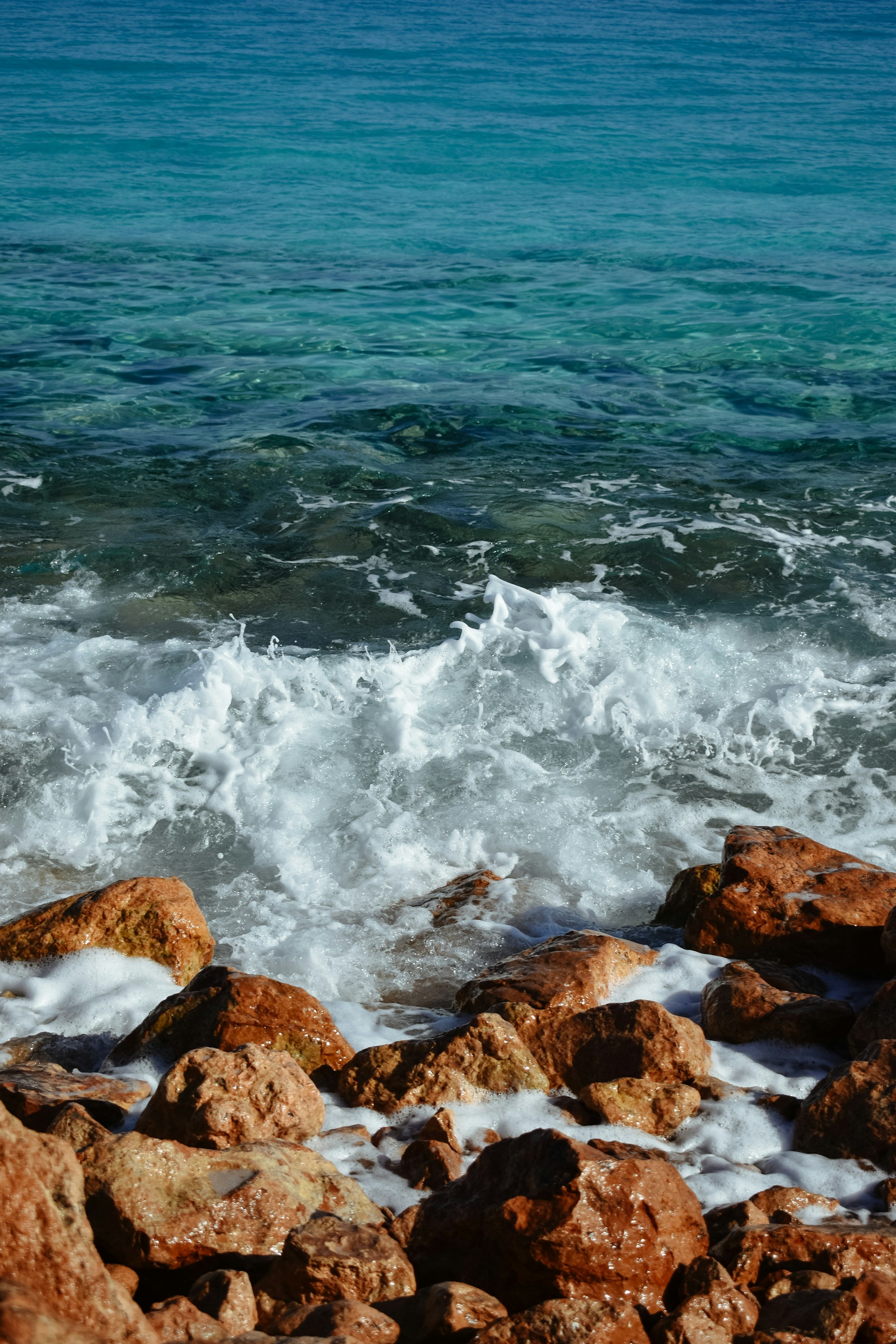 A surfboard that is sitting on some rocks
