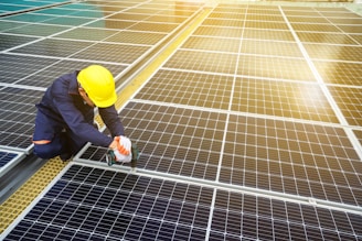 A man in a hardhat working on a solar panel