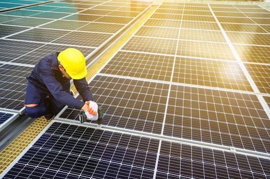 A man in a hardhat working on a solar panel