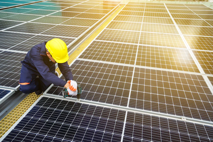 Installer in a hard hat working on a solar panel