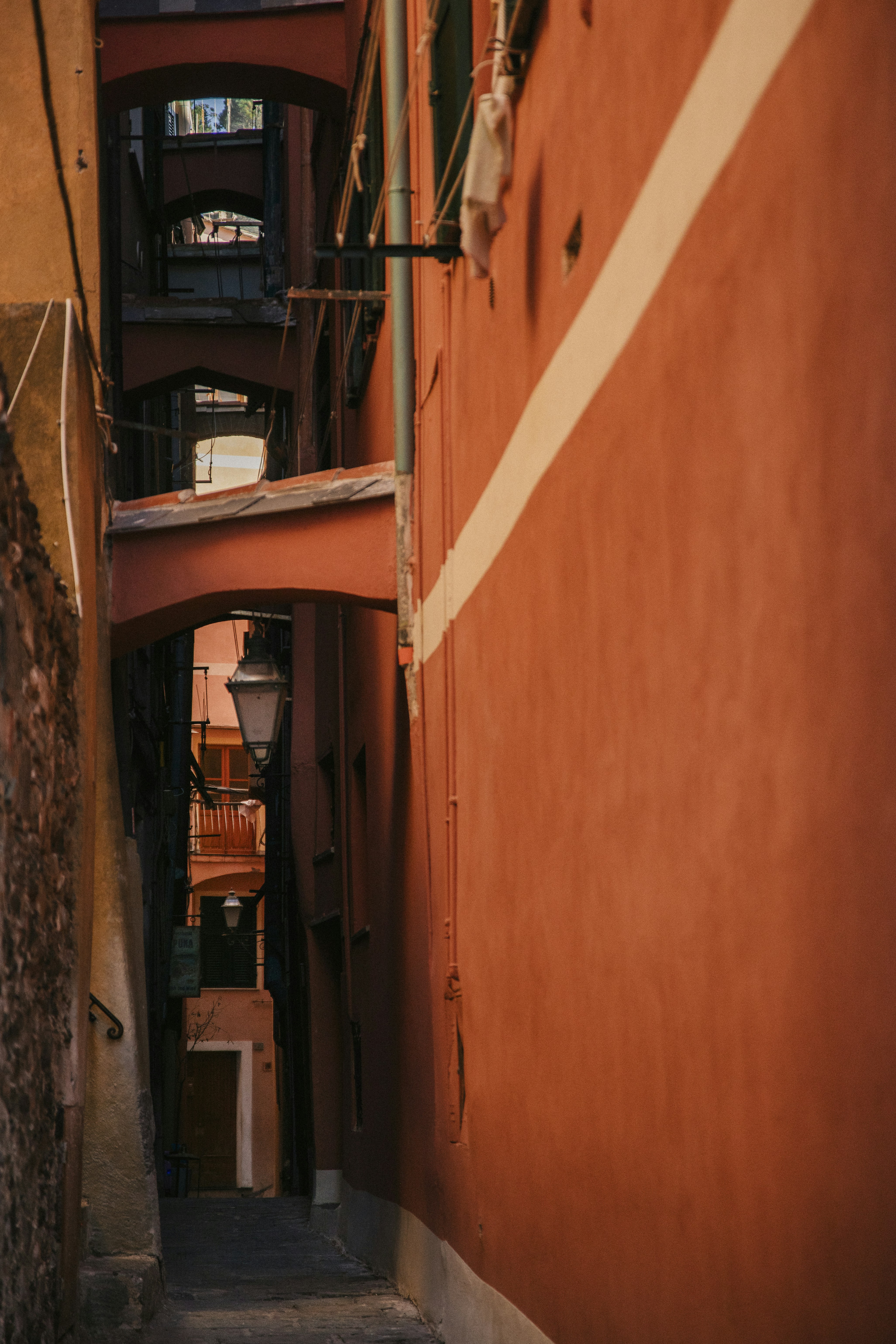 A narrow alley way with a red building in the background