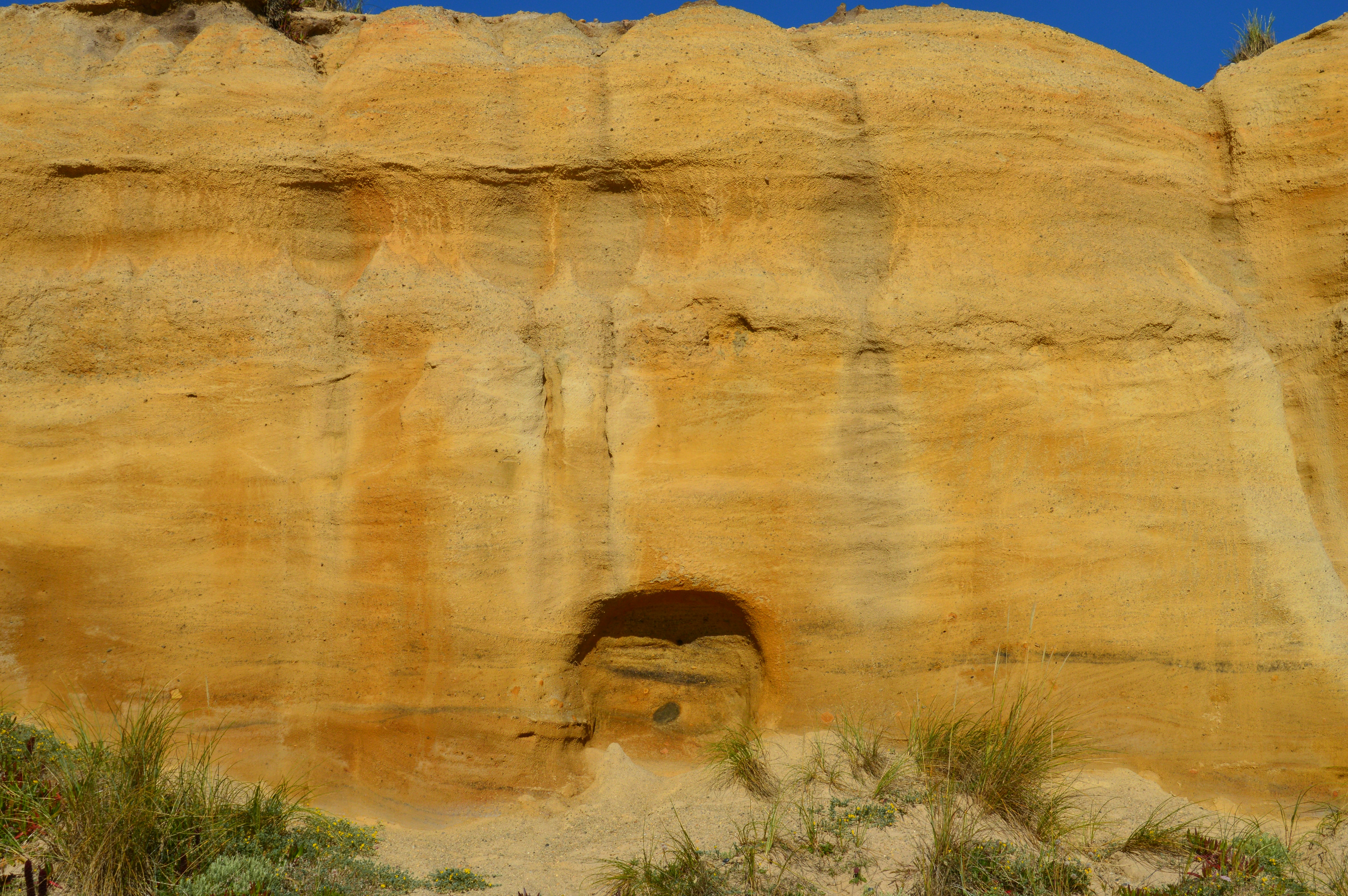A rock formation with a cave in the middle of it