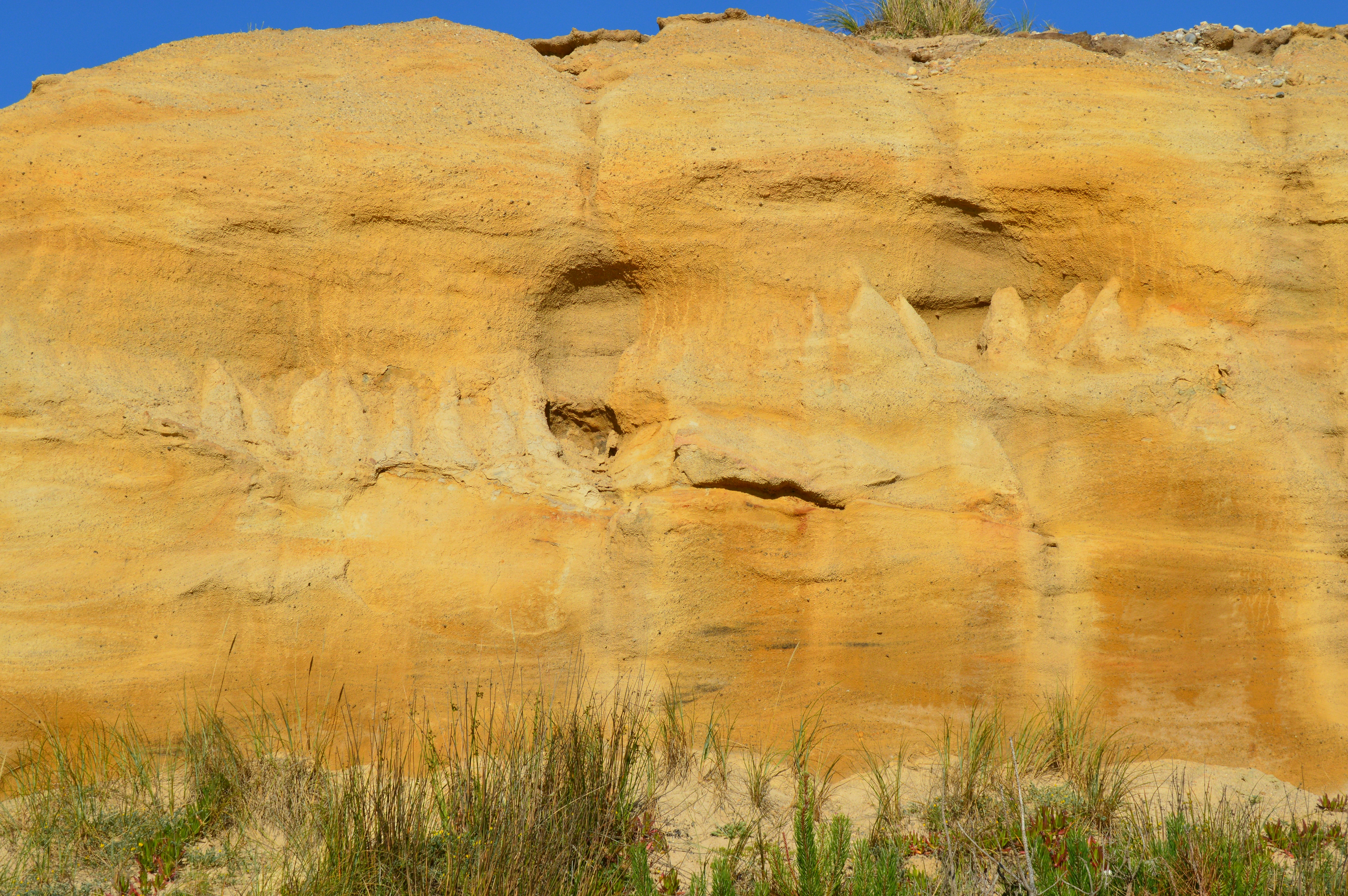 A large rock formation with a blue sky in the background
