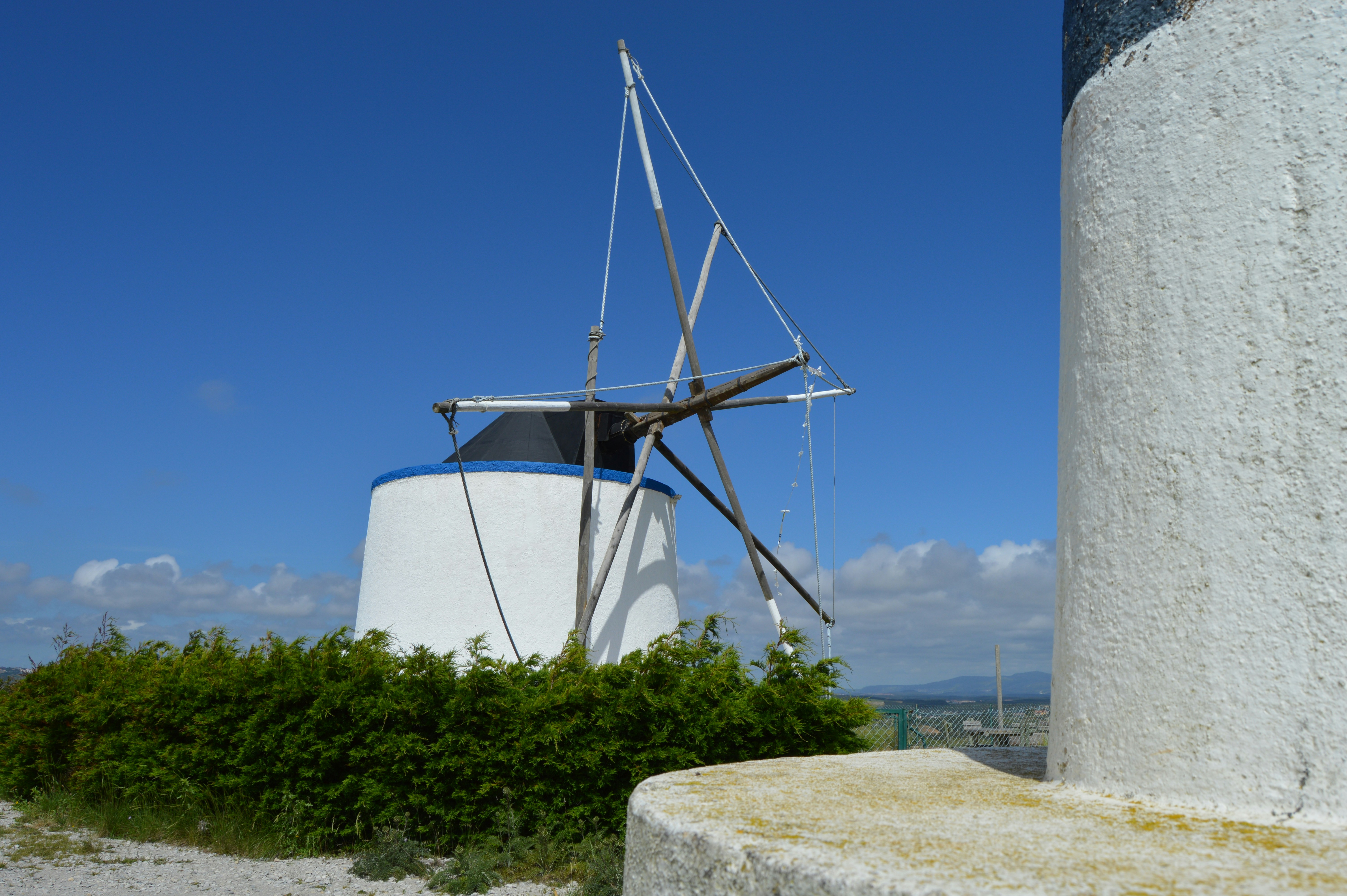 A white windmill next to a cement wall