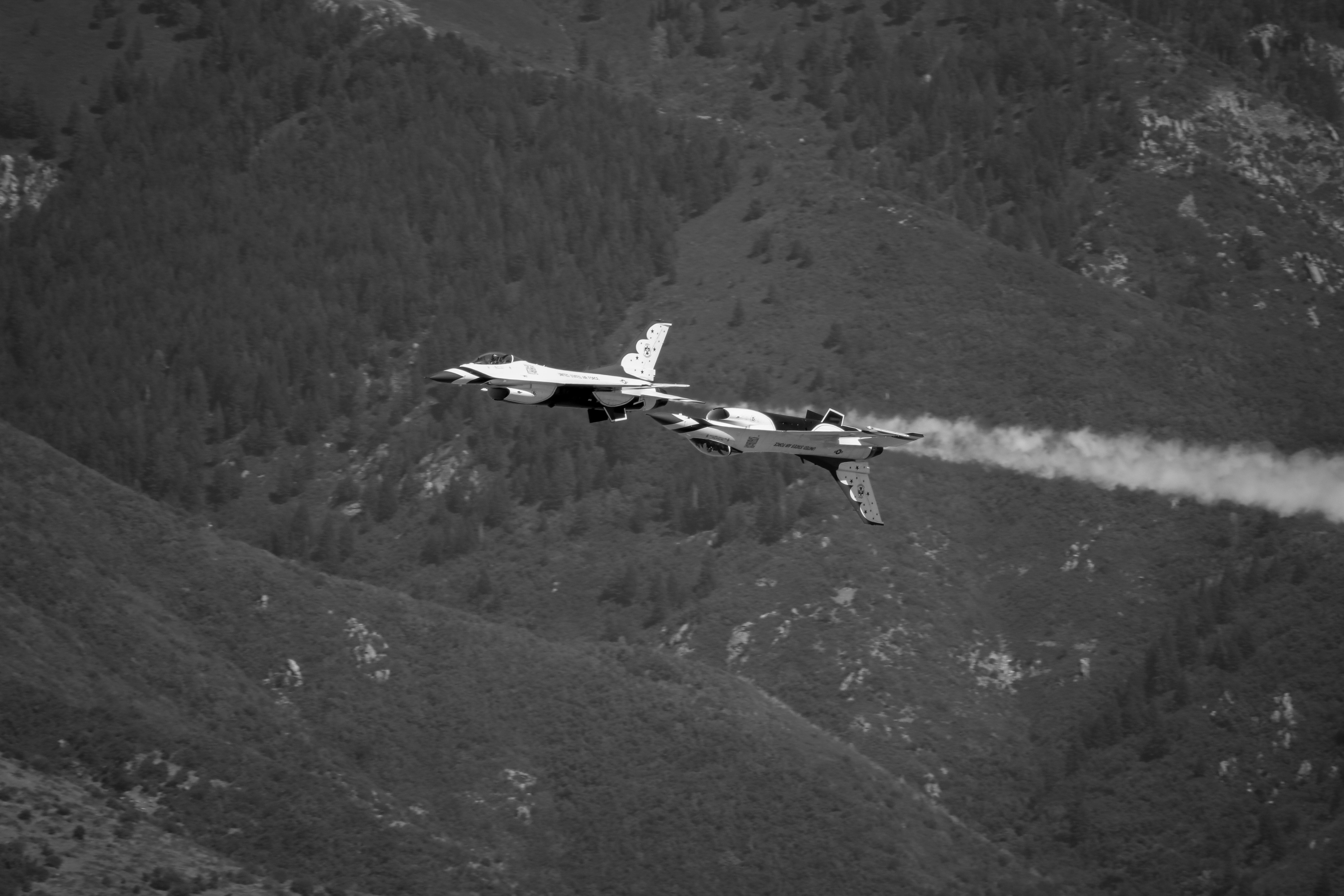 A small plane flying over a lush green hillside