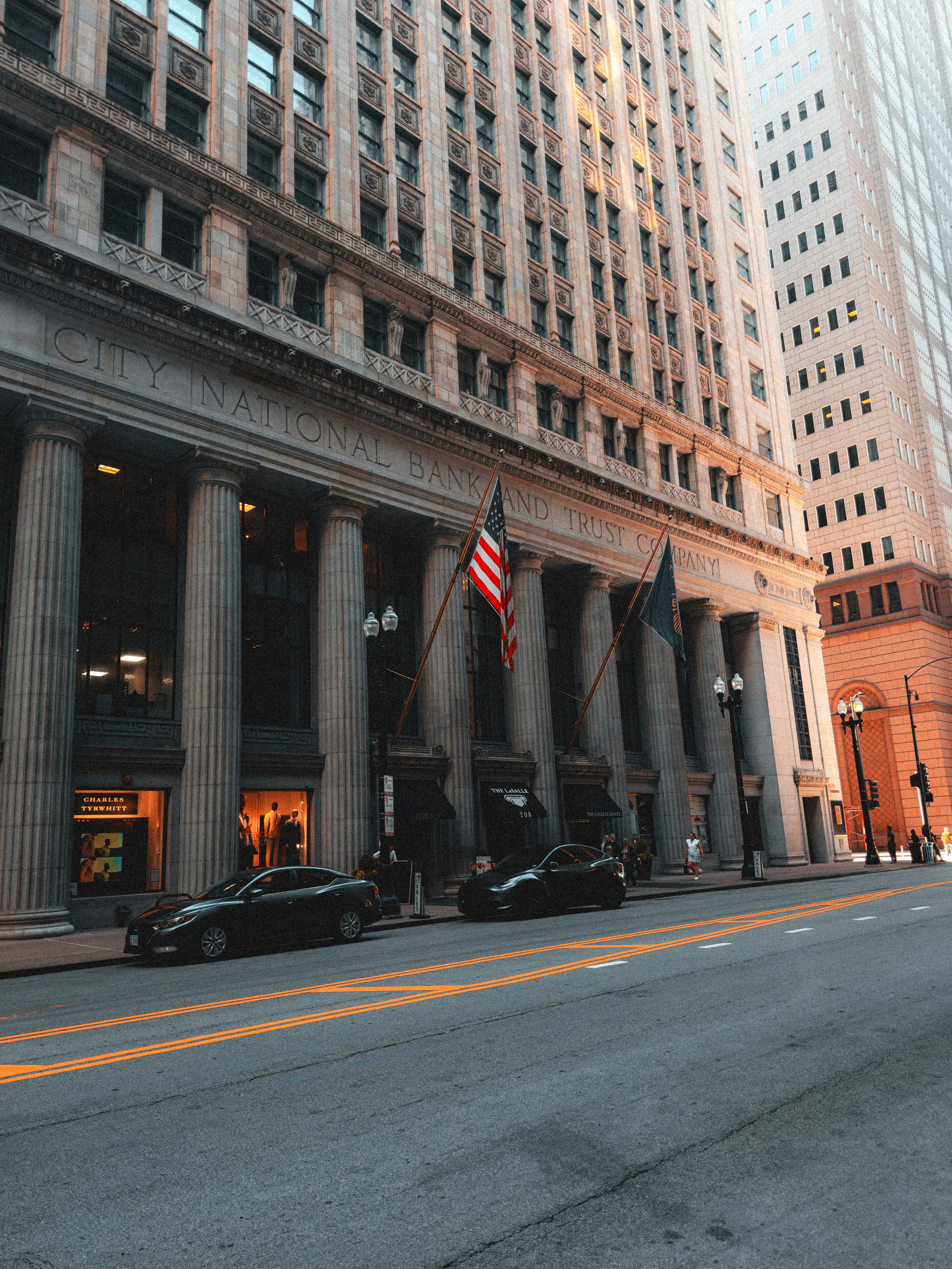 A city street lined with tall buildings and flags