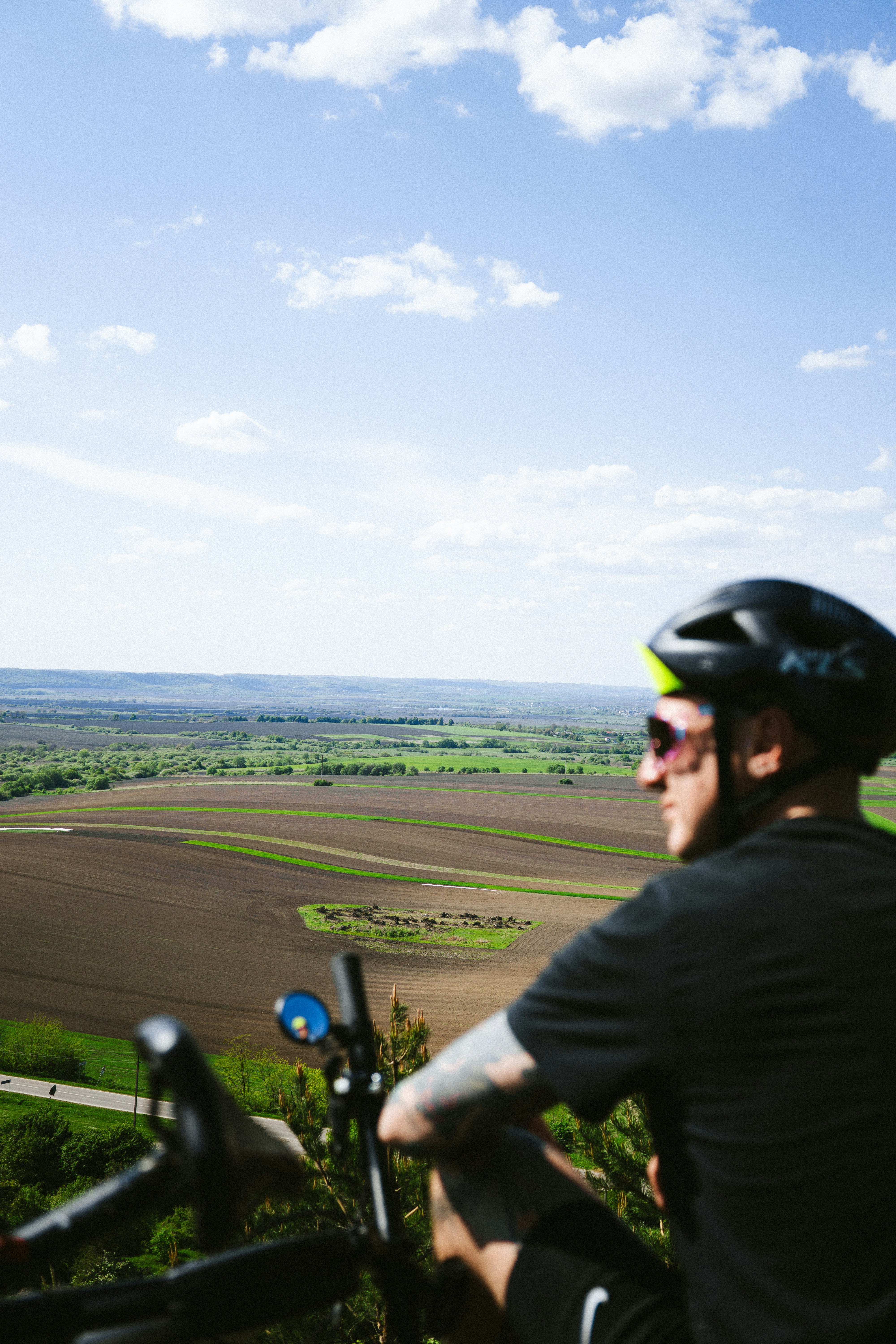 A man riding a bike on top of a lush green hillside