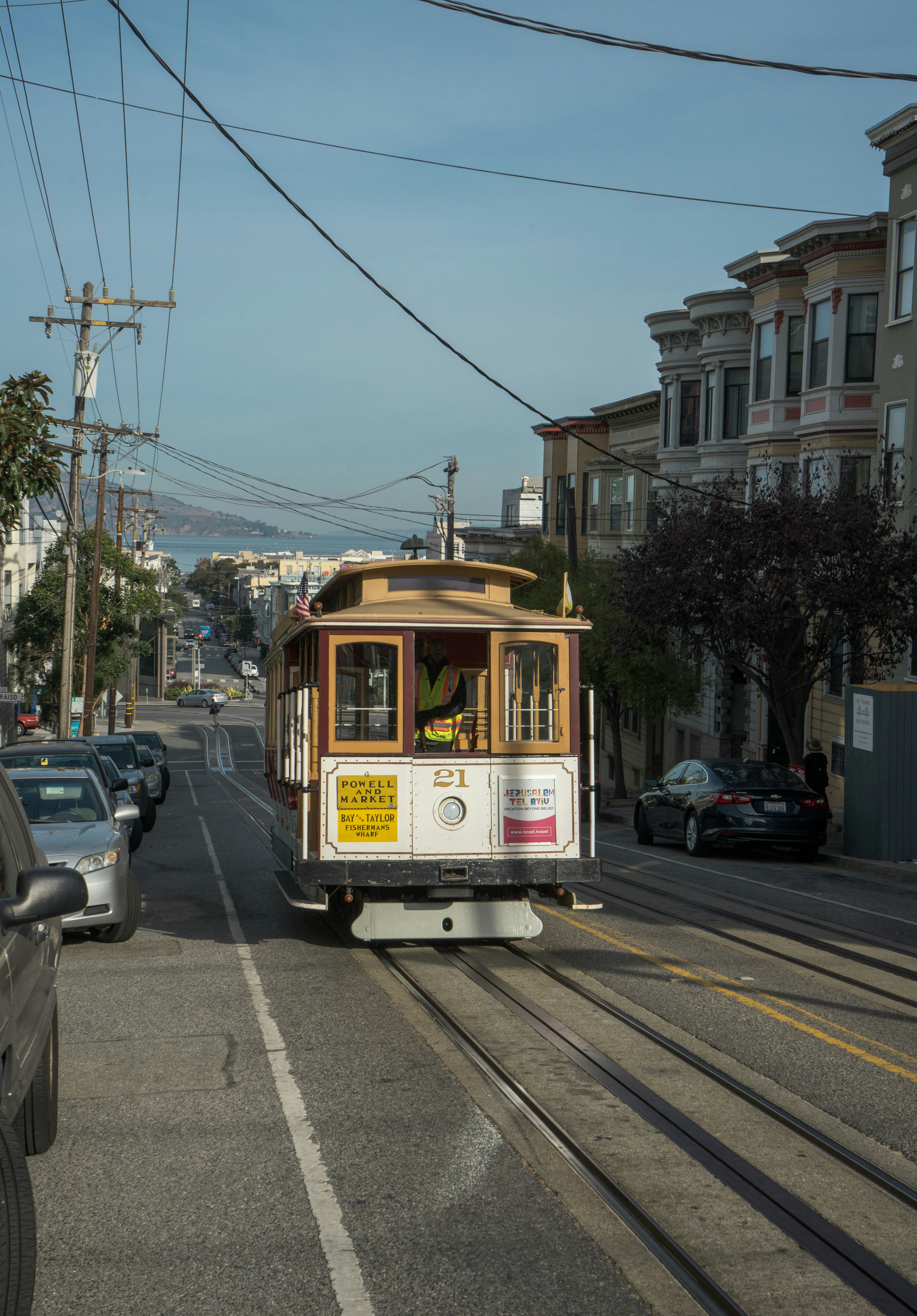 A trolley car is traveling down the street