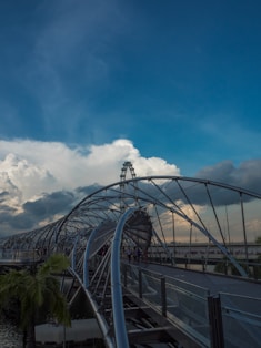 A roller coaster going over a bridge on a cloudy day