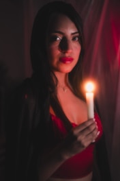 A woman holding a candle in a dark room