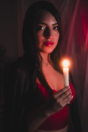 A woman holding a candle in a dark room
