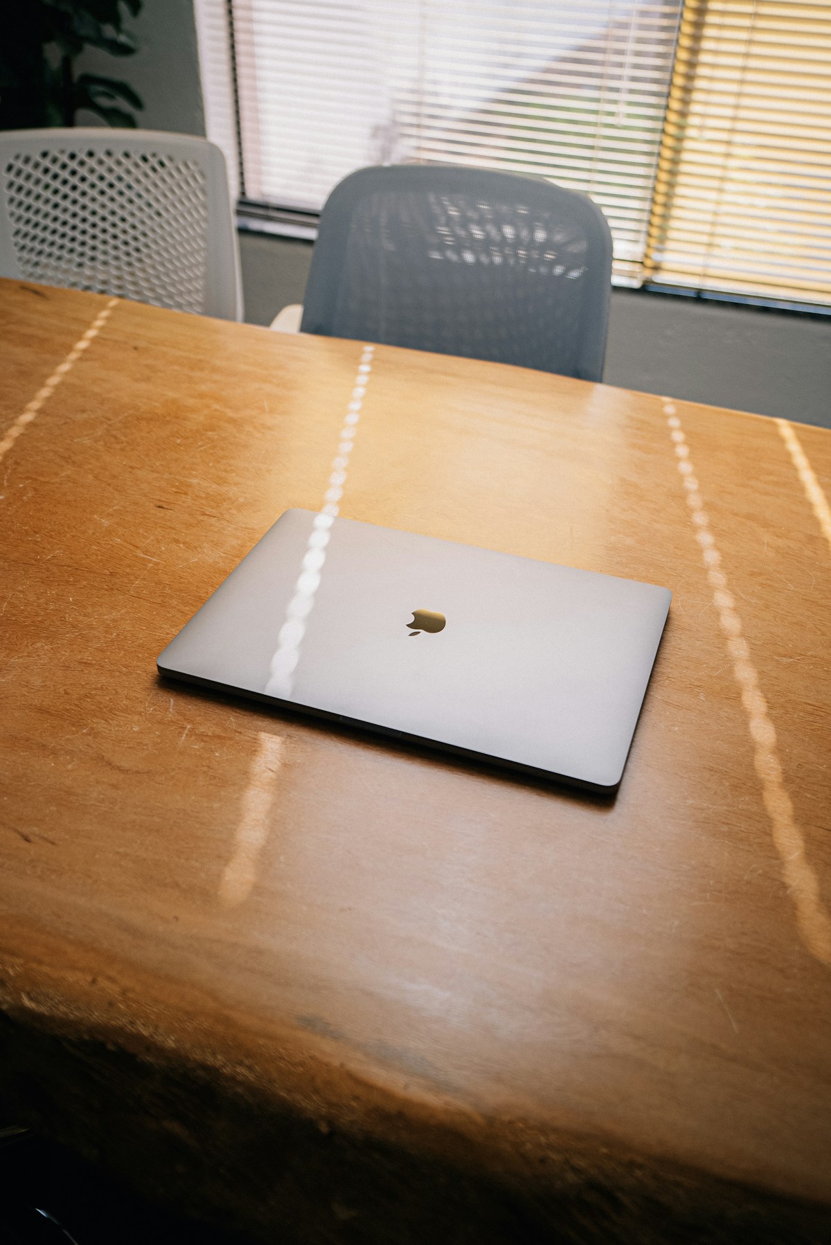 An apple laptop sitting on a wooden table
