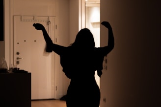 A woman standing in a room with her arms in the air