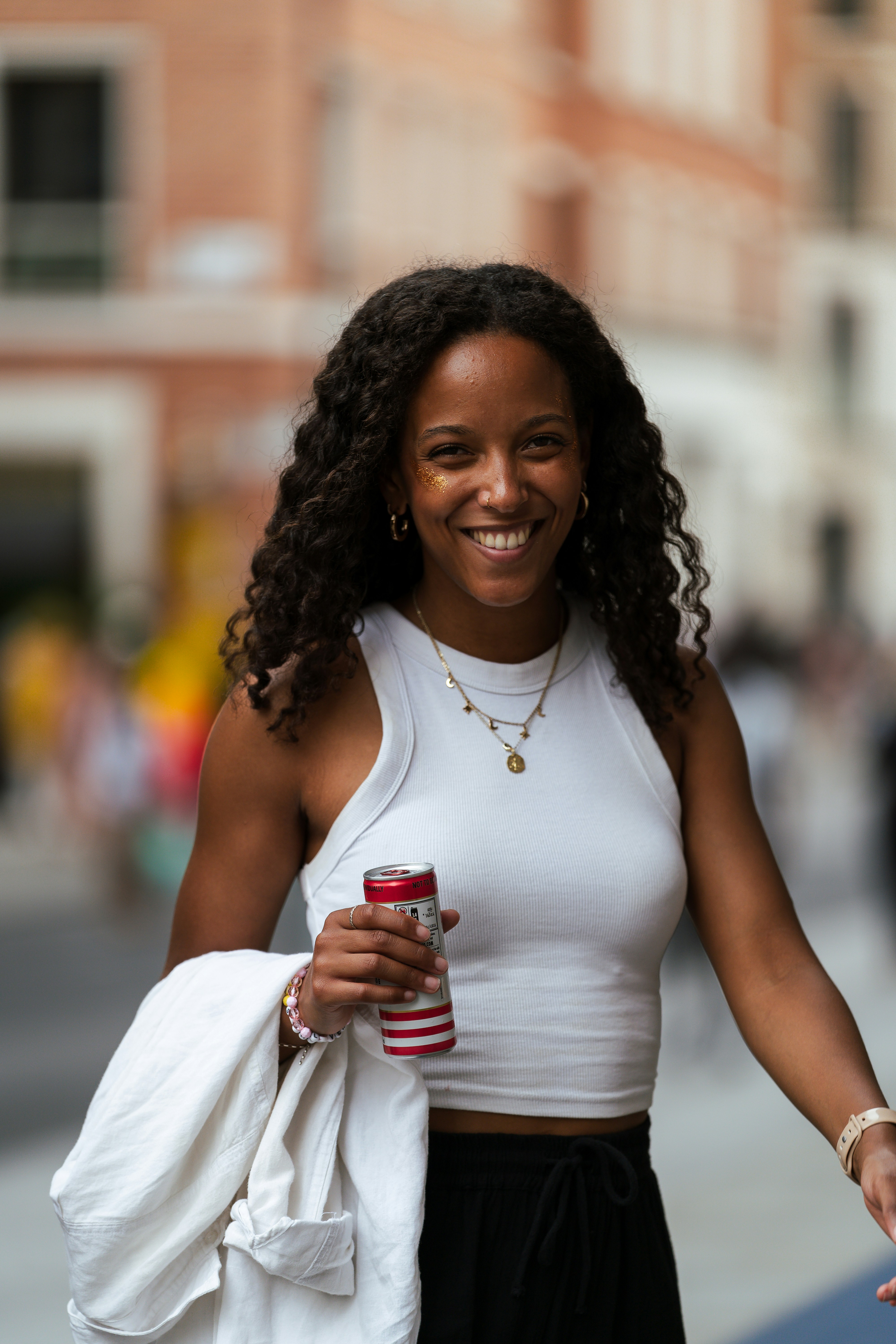 A woman walking down a street holding a cup of coffee