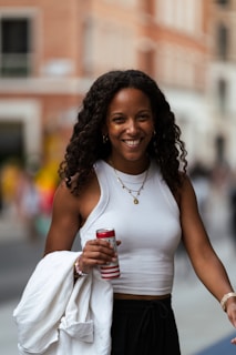 A woman walking down a street holding a cup of coffee