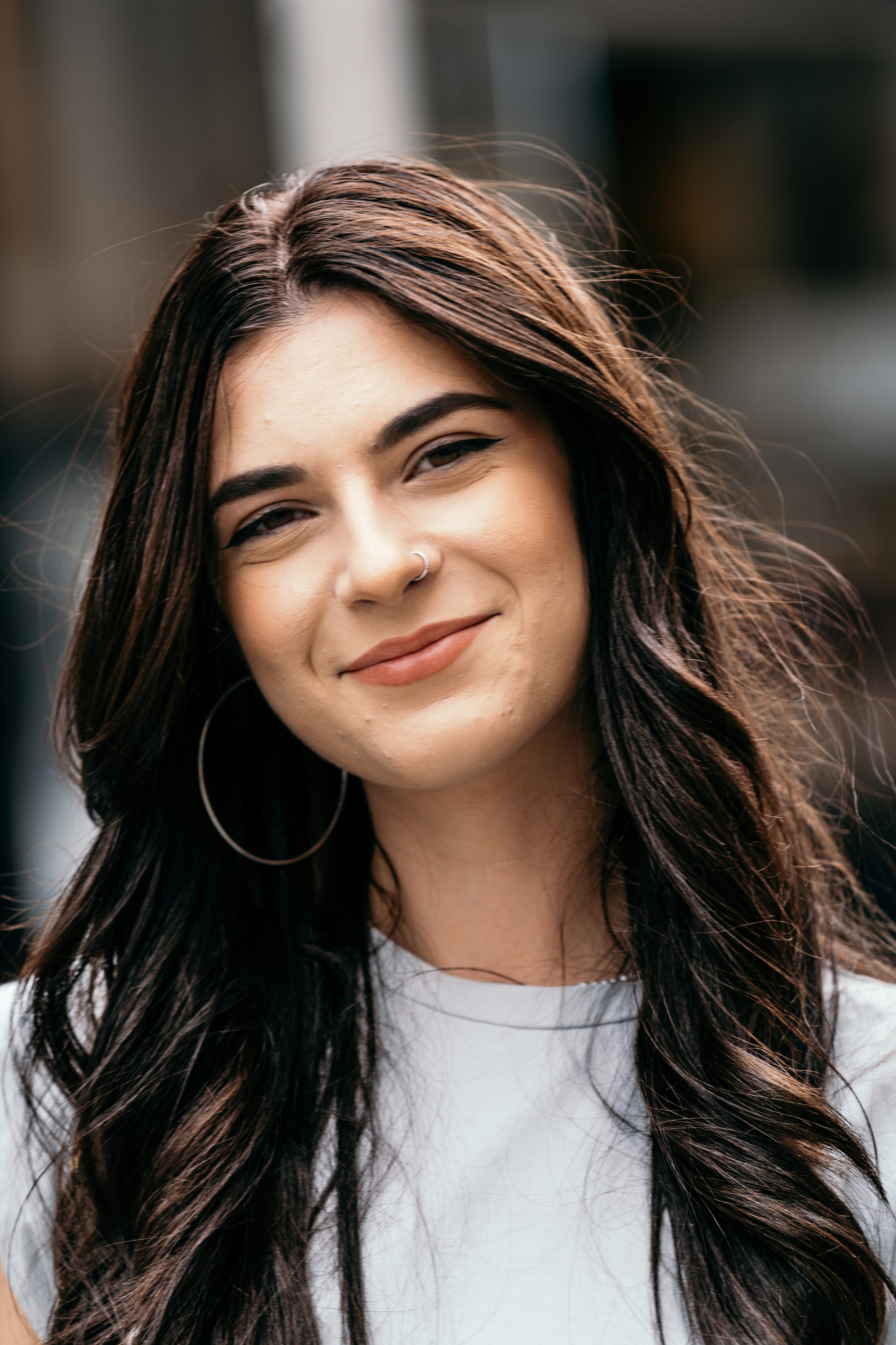 A woman with long brown hair and large hoop earrings