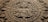 A stone carving of a face with many symbols on it