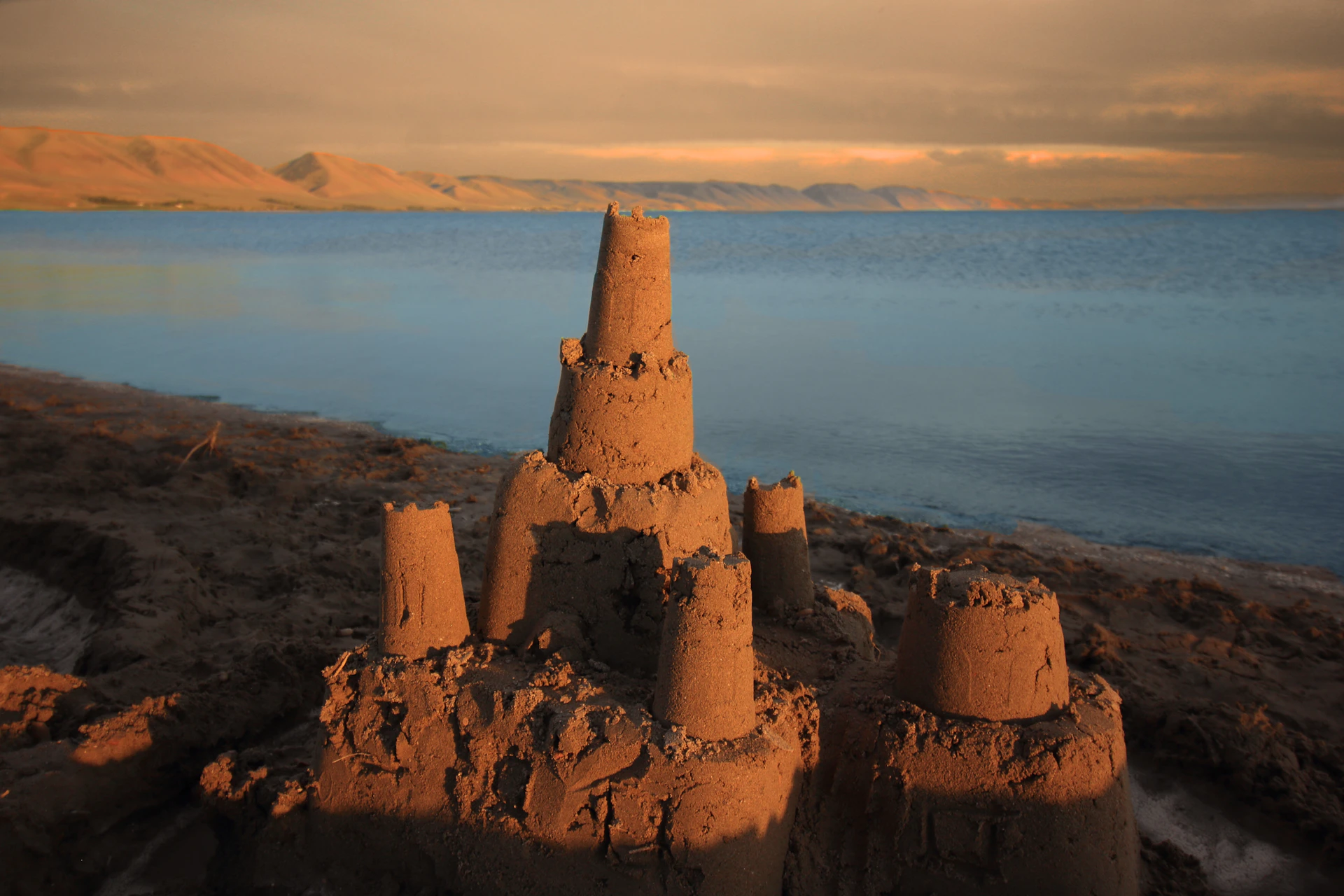 A sand castle sitting on top of a sandy beach