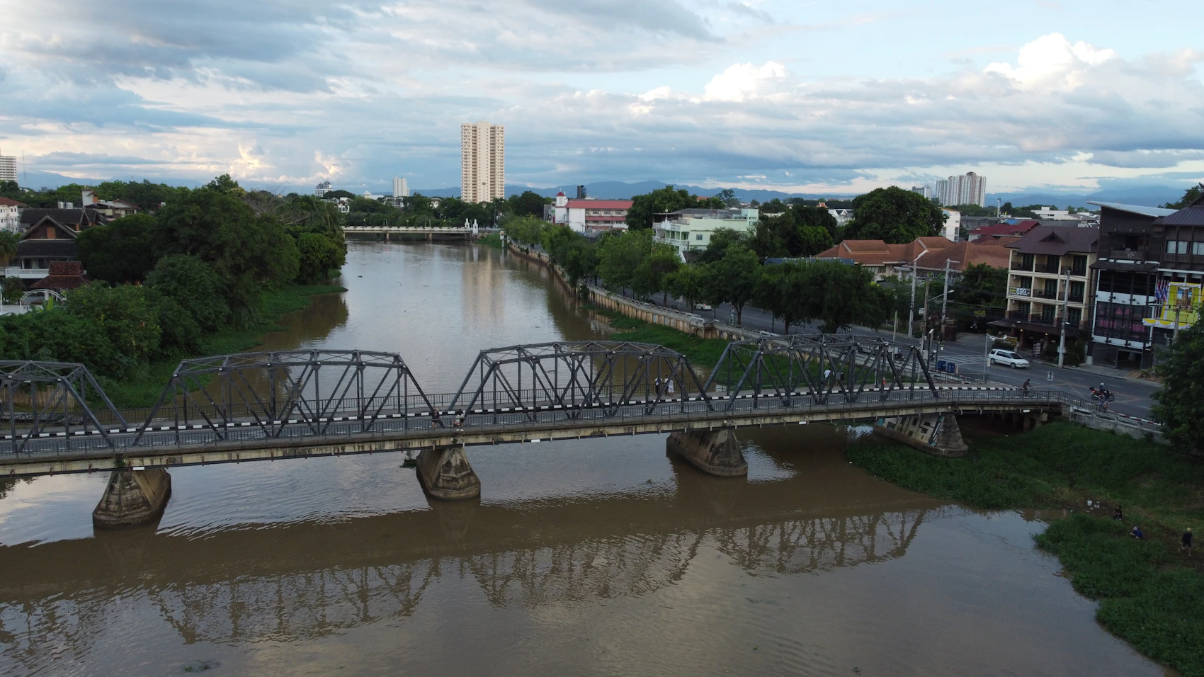 The Ping River and an iron bridge crossing central Chiang Mai beneath monsoon clouds