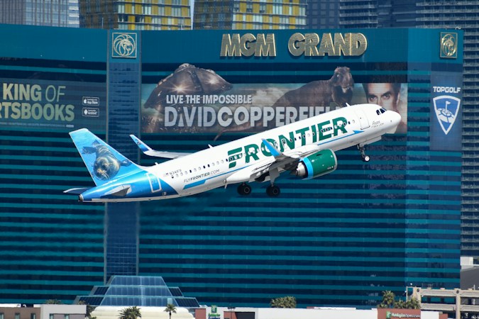 A passenger jet flies low over the Las Vegas Strip on approach, showing how close the airport sits to the resort corridor and nearby neighborhoods