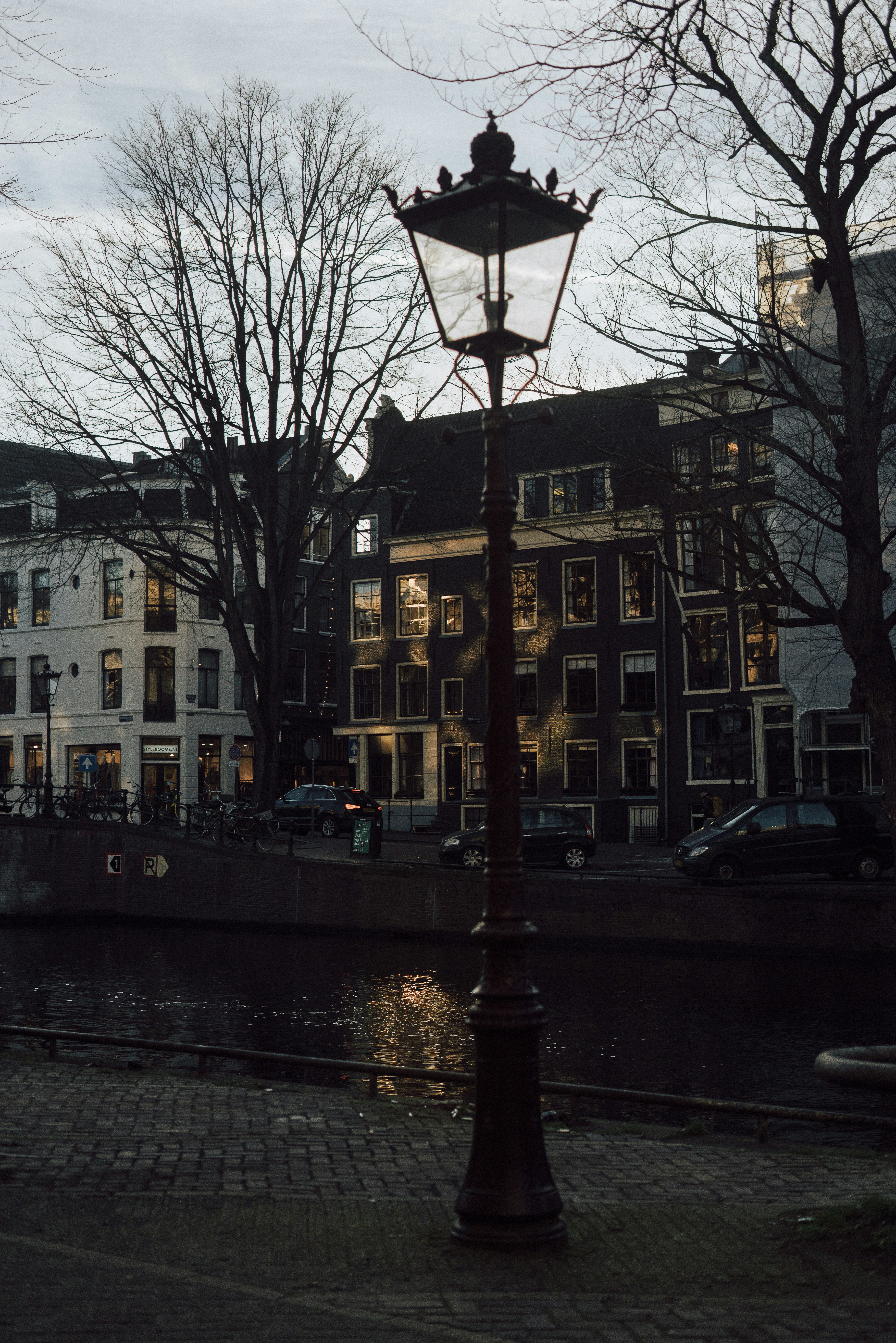 A lamp post sitting next to a body of water