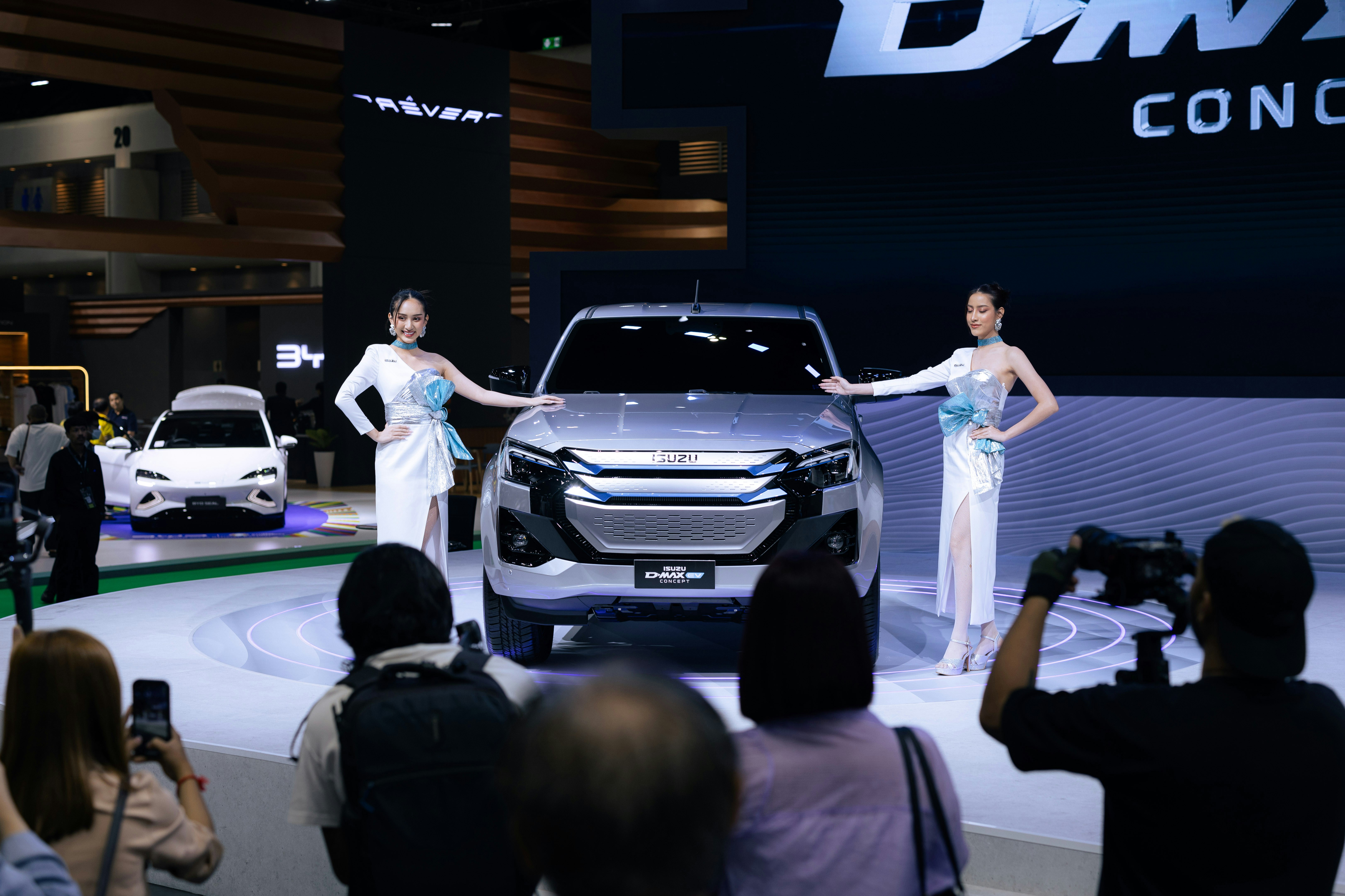 A couple of women standing next to a silver car