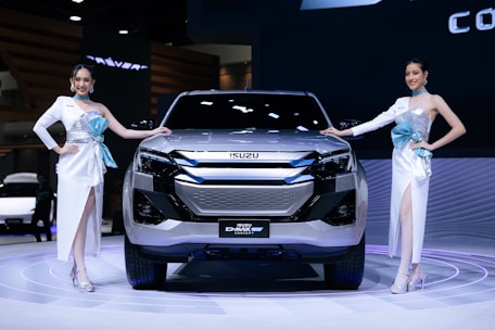 A couple of women standing next to a silver car