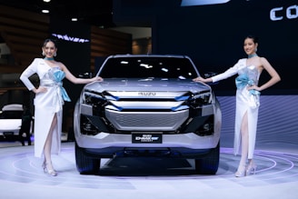 A couple of women standing next to a silver car