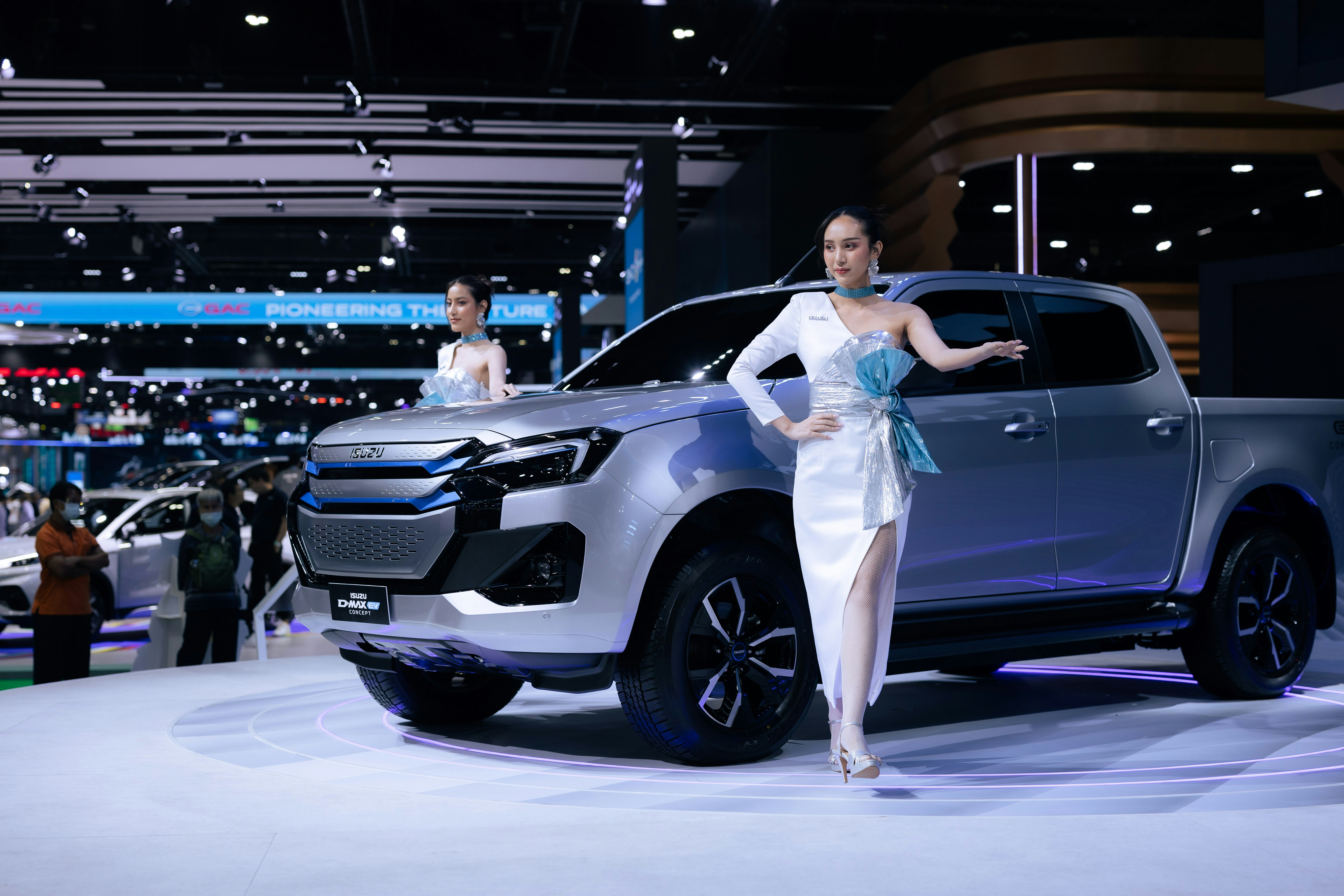 A woman standing next to a silver truck