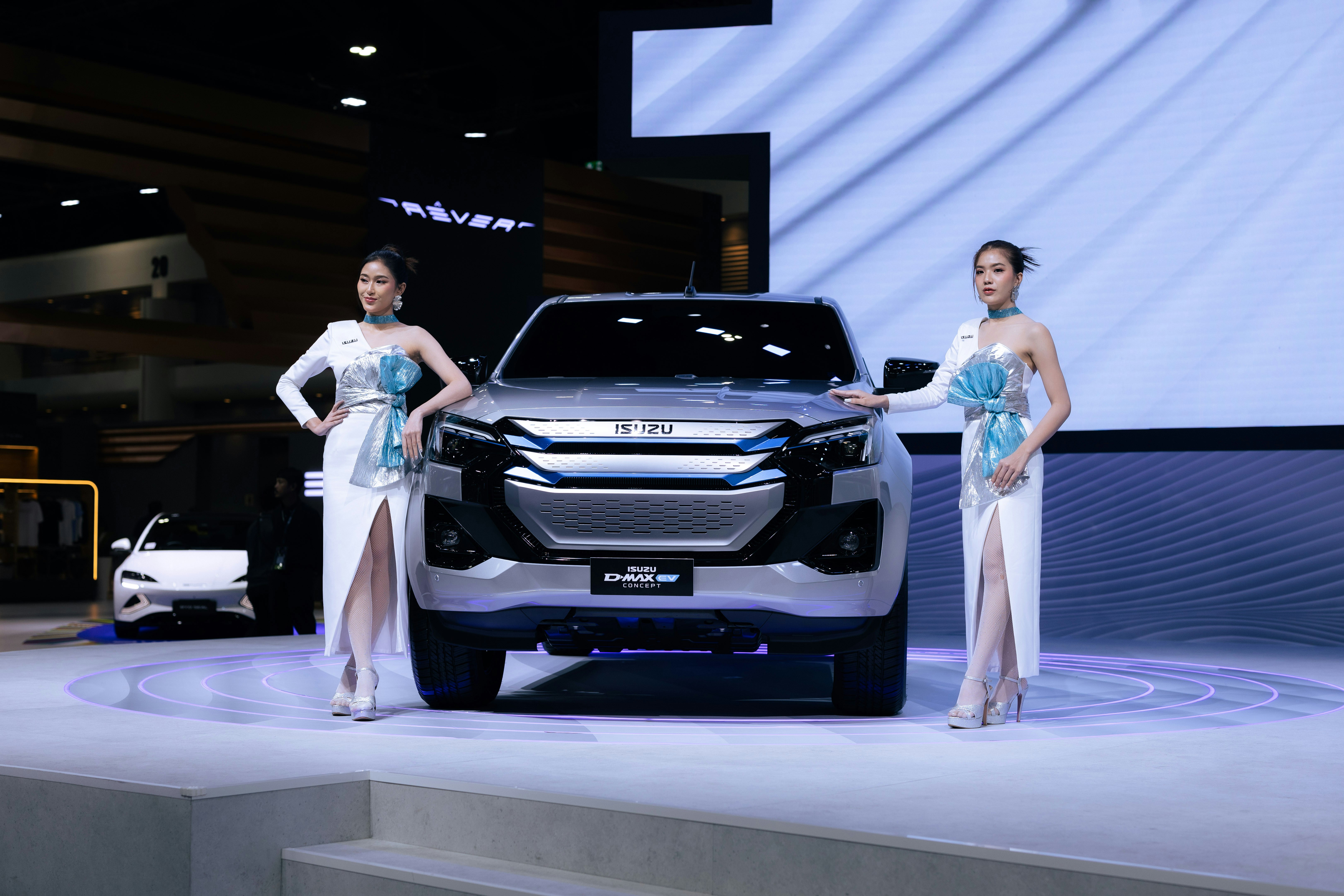 Two women standing next to a silver truck