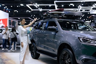 A woman standing next to a gray suv