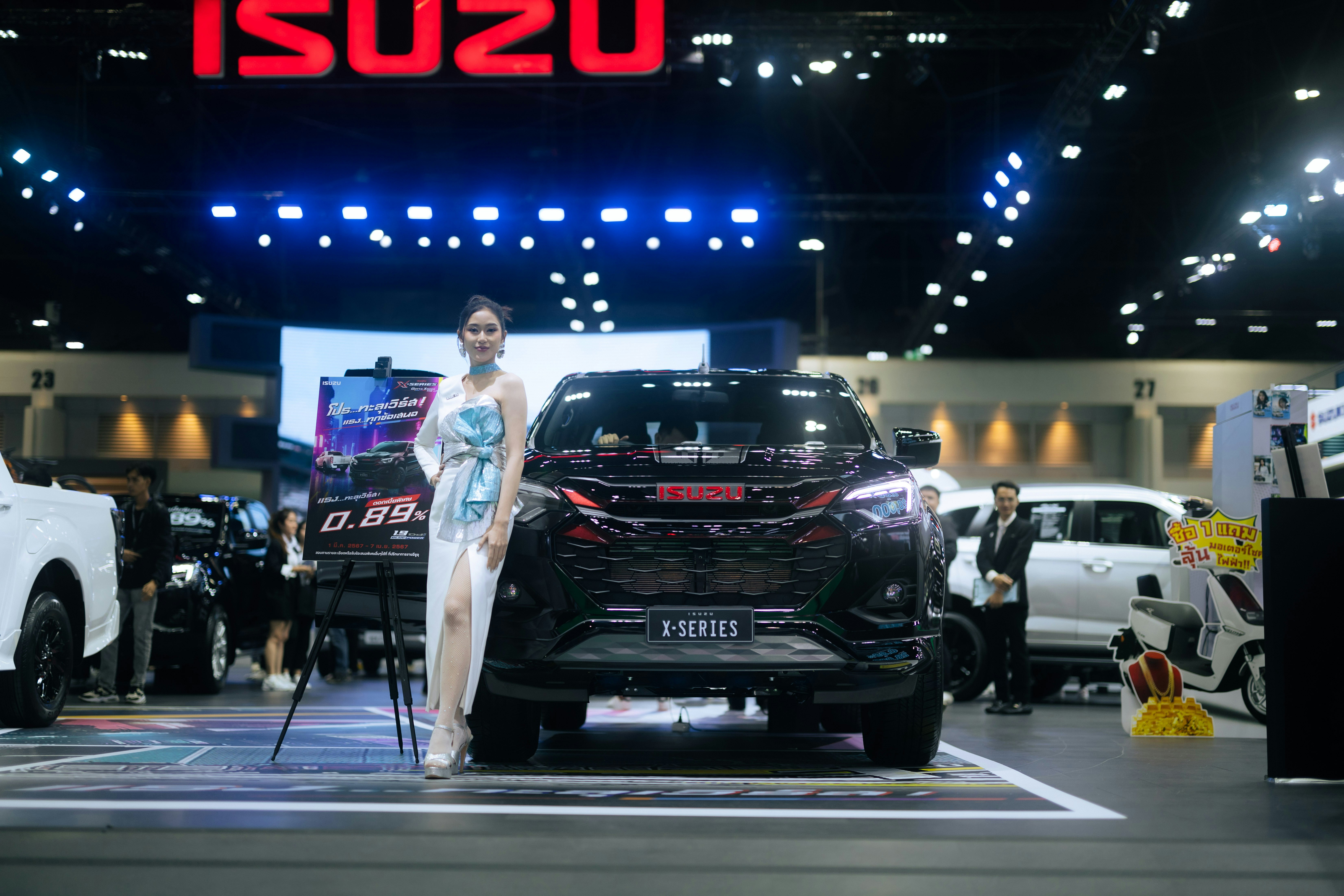 A woman standing in front of a car at a show
