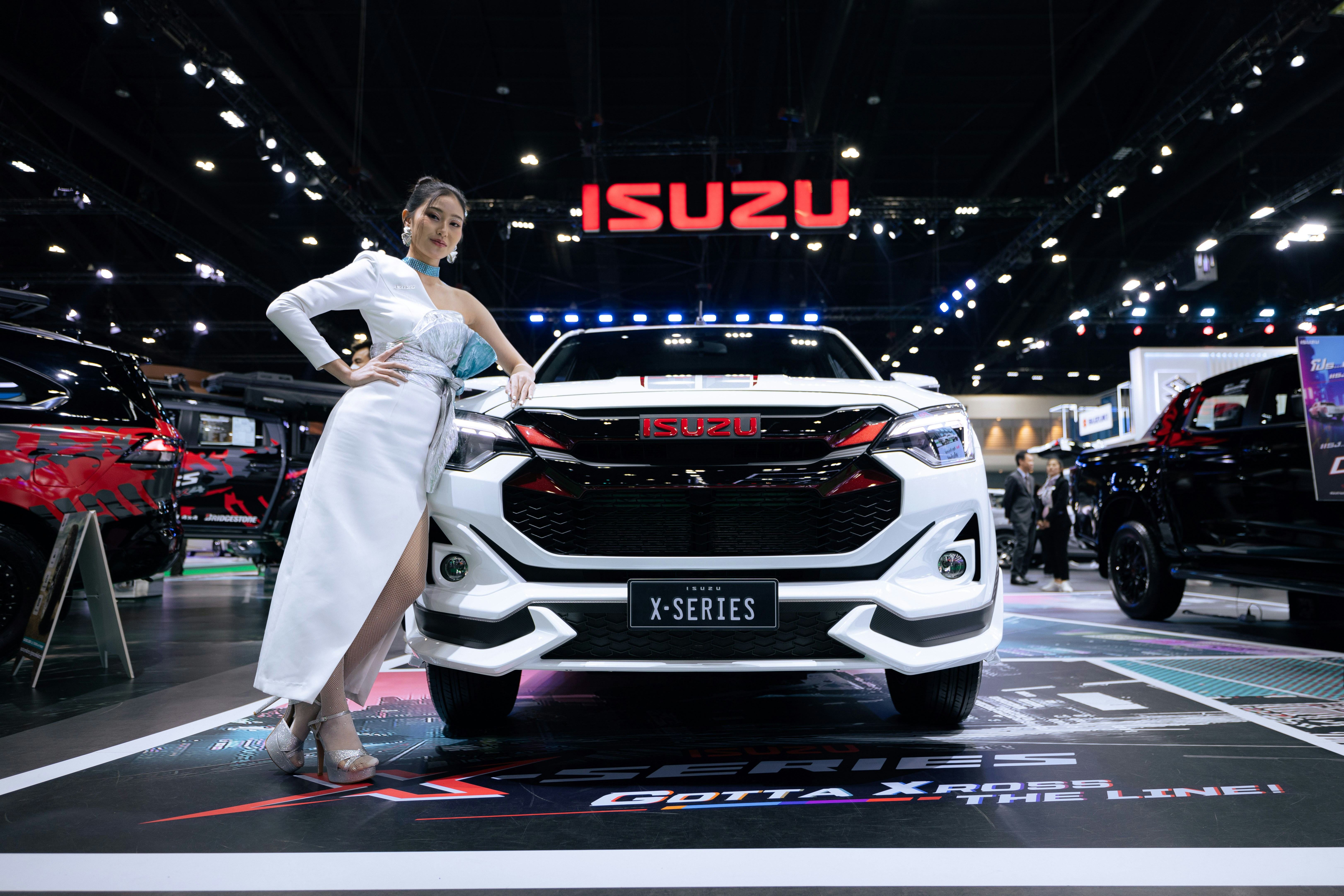 A woman in a white dress standing next to a white car