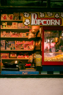 A store front with a popcorn machine in front of it