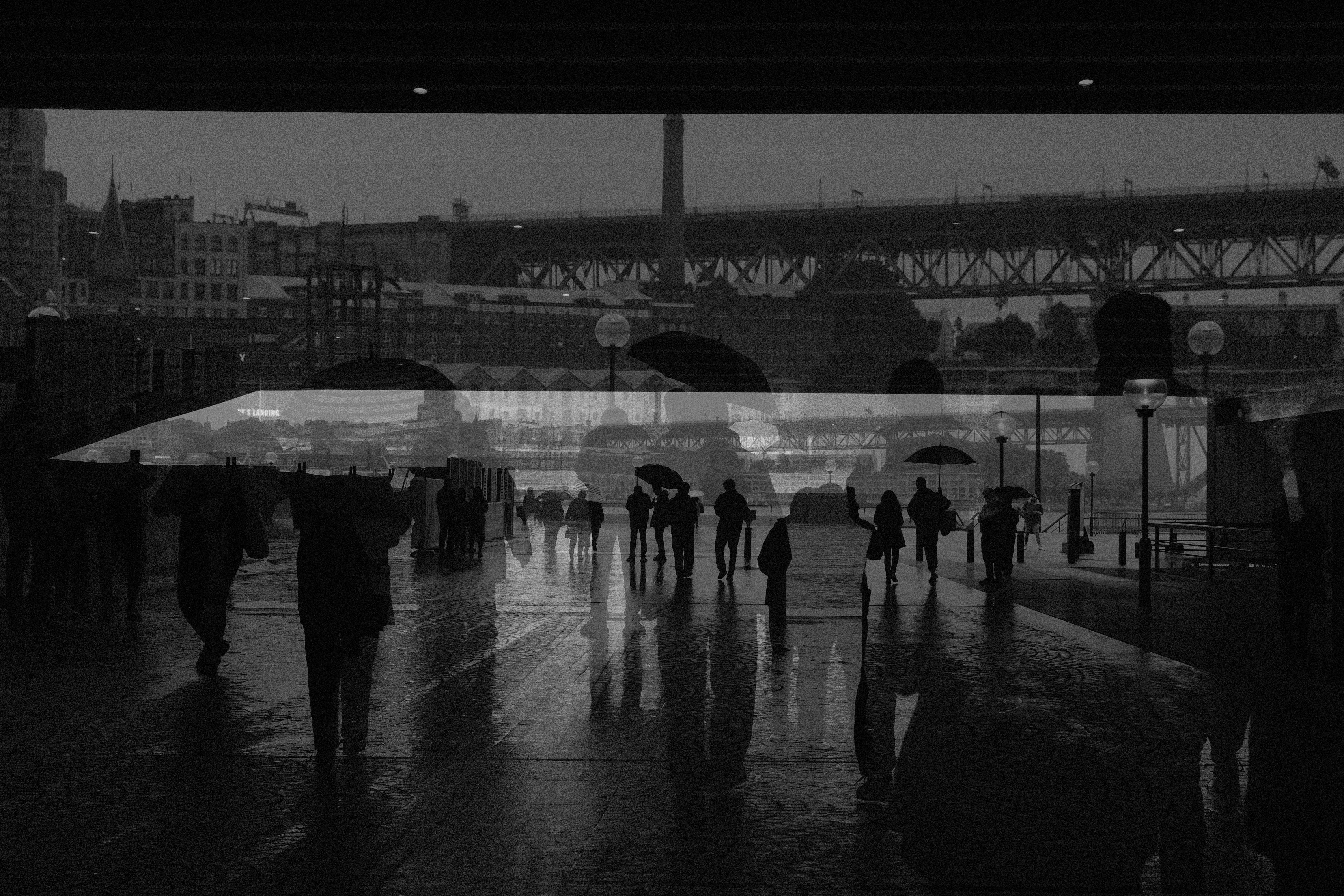 A black and white photo of people walking in the rain