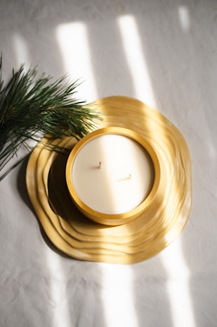 A candle sitting on top of a table next to a pine tree