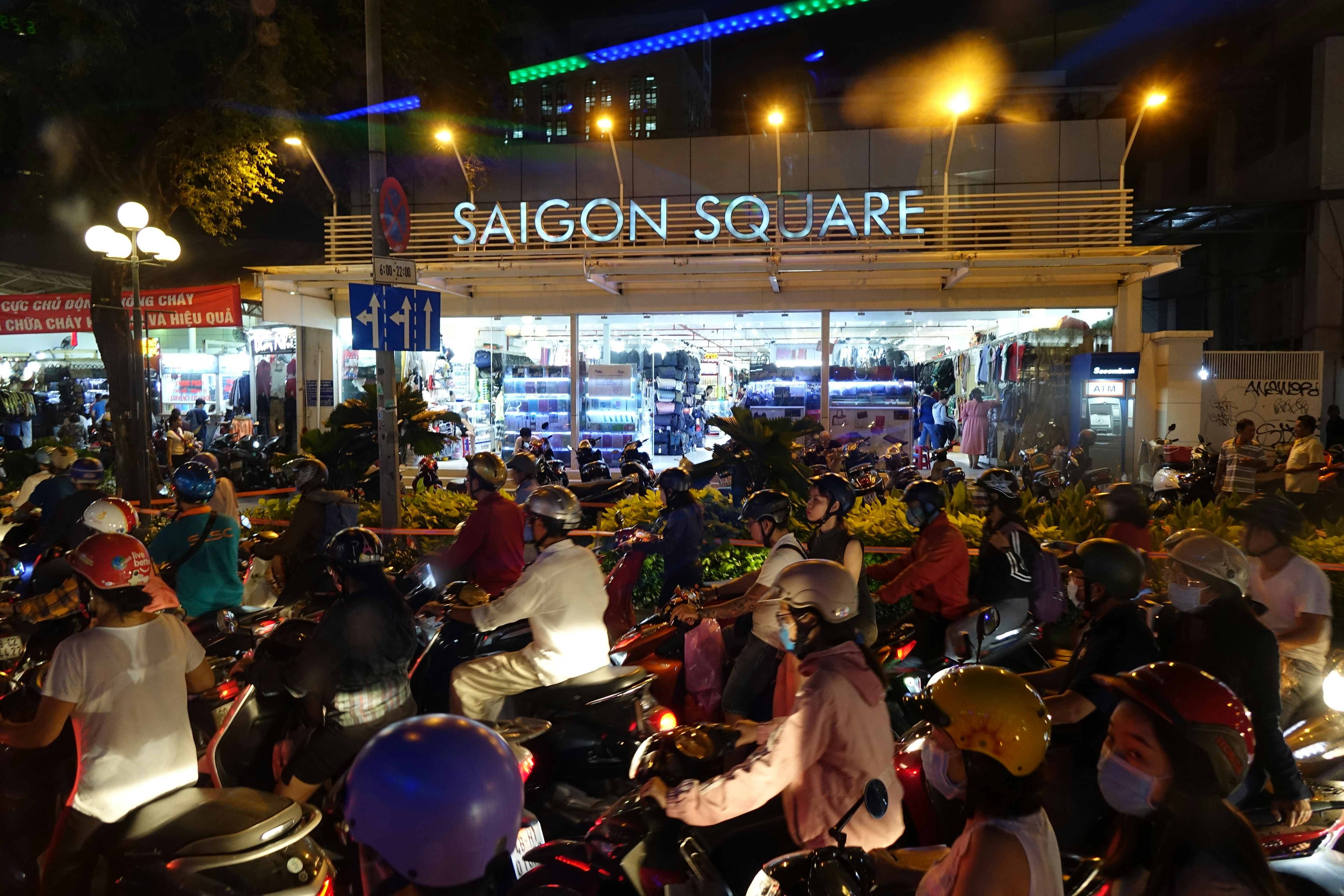 A large group of people riding motorcycles down a street